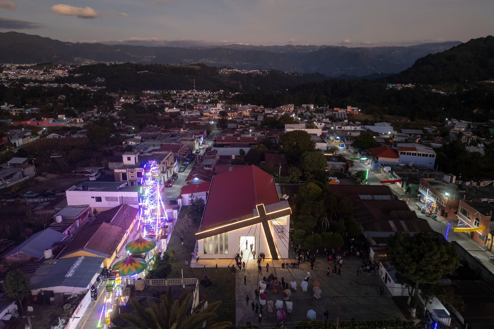 The Black Christ of Esquipulas church is illuminated prior to a procession the night before its feast day in Esquipulas Palo Gordo, in Guatemala's San Marcos department, Tuesday, Jan. 14, 2025. (AP Photo/Moises Castillo)