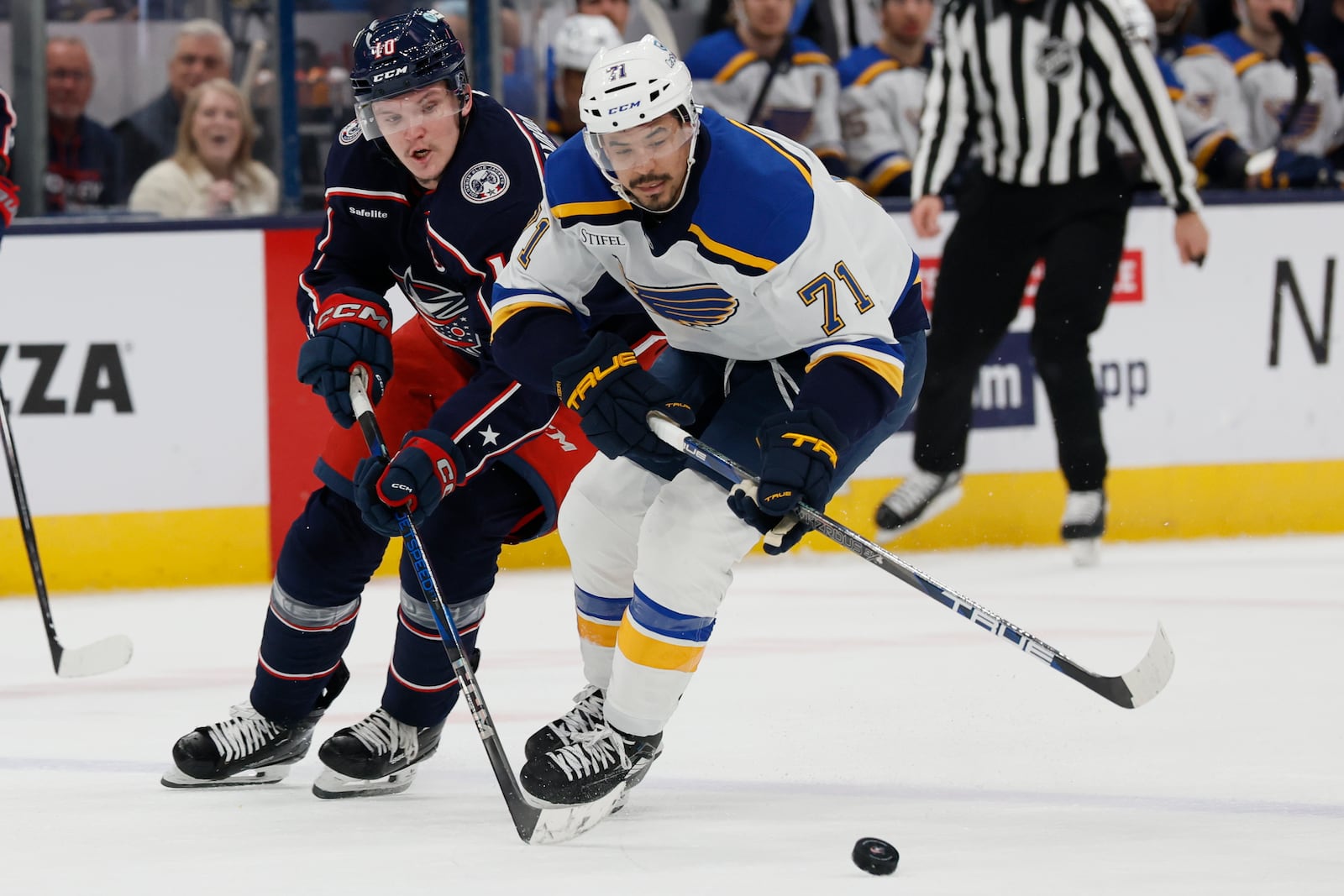 St. Louis Blues' Mathieu Joseph, right, and Columbus Blue Jackets' Dmitri Voronkov chase the puck during the third period of an NHL hockey game Saturday, Jan. 4, 2025, in Columbus, Ohio. (AP Photo/Jay LaPrete)