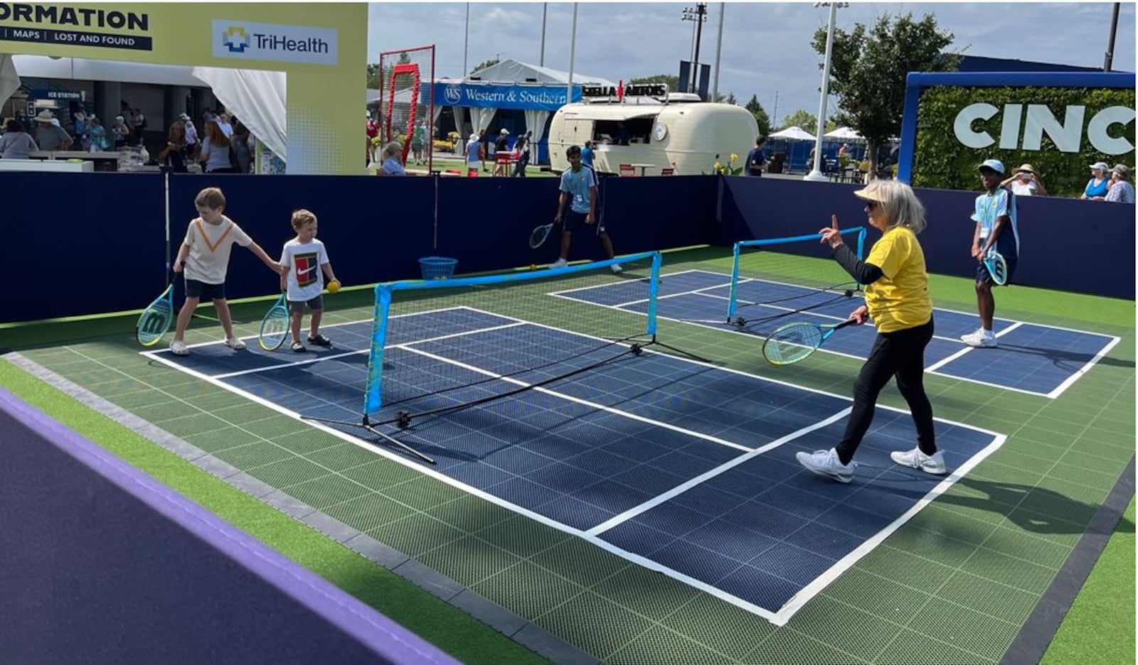 As action continues on Center Court and other courts during the Western & Southern Open, young fans can play on a mini tennis court in the Fan Zone, a new amenity at the tournament. ED RICHTER/STAFF