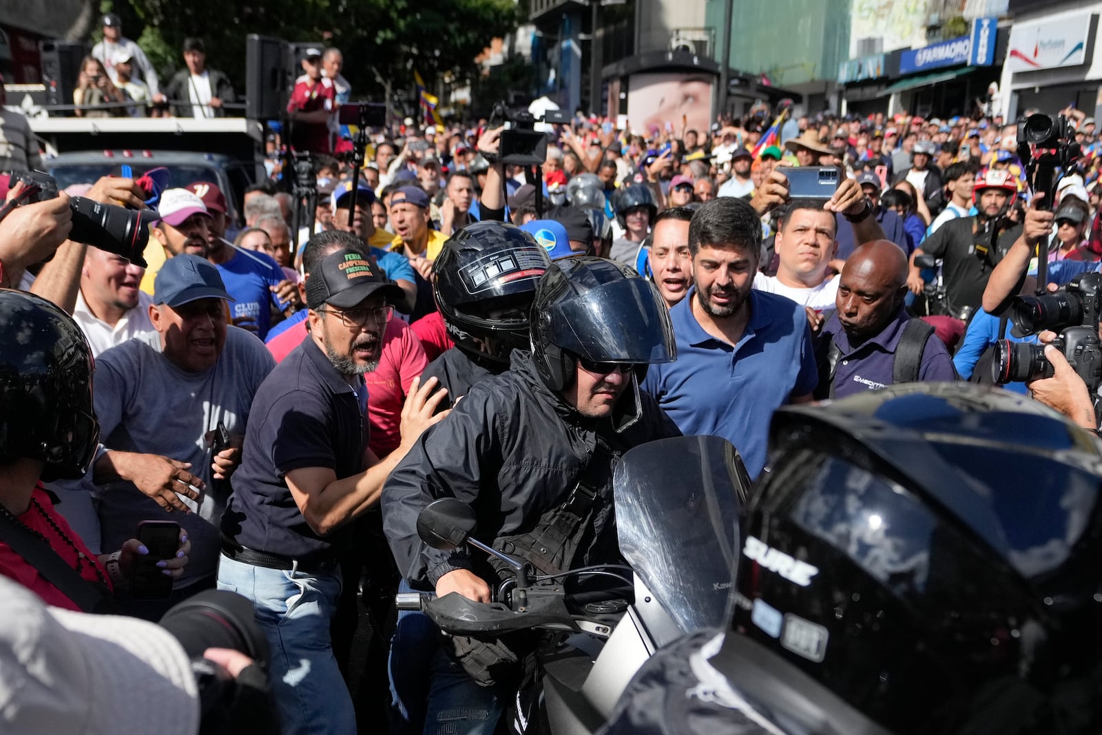 Opposition leader Maria Corina Machado, wearing a helmet, sits on the back of a motorcycle as she is driven away after addressing people at a protest against President Nicolas Maduro in Caracas, Venezuela, Thursday, Jan. 9, 2025, the day before his inauguration for a third term. (AP Photo/Matias Delacroix)