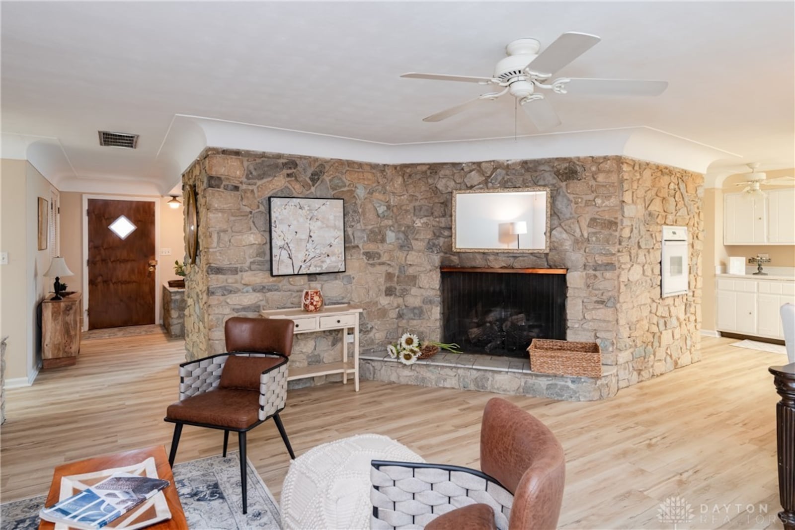 The stone fireplace in the gathering room is a focal point. The stone continues into the kitchen and there is a wall oven inset.