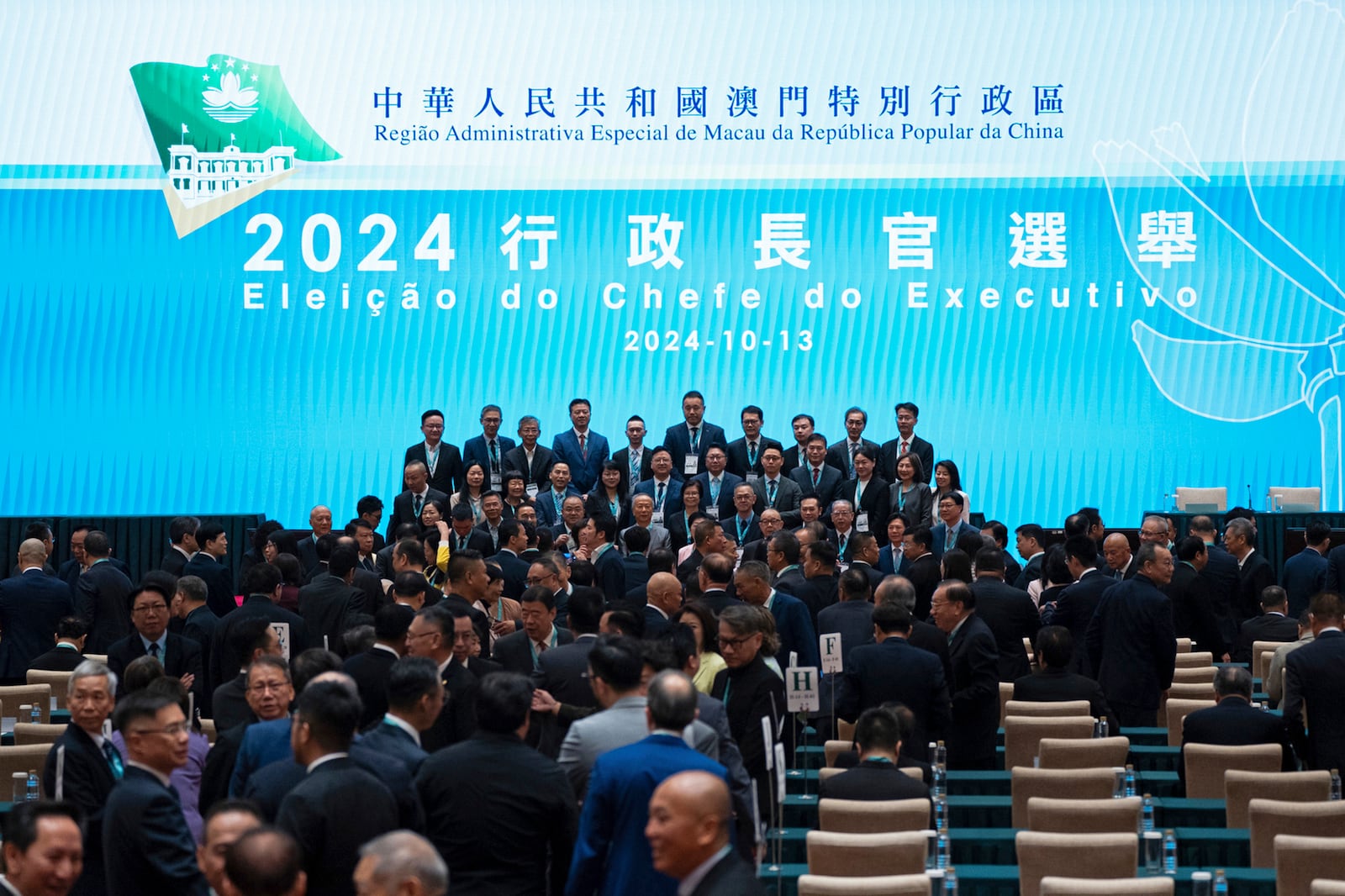 Election committee members pose for photos ahead of the chief executive election in Macao, Sunday, October 13, 2024. (AP Photo/Bertha Wang)