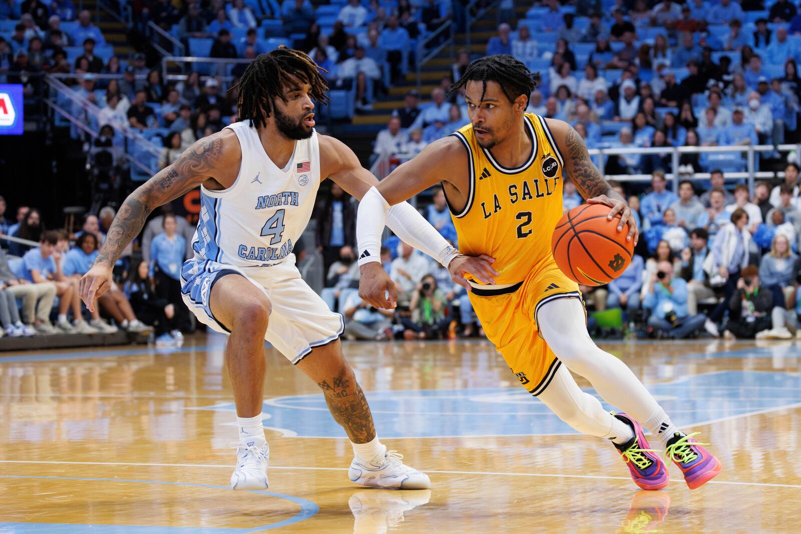 La Salle's Corey McKeithan (2) drives as North Carolina's RJ Davis (4) defends during the second half of an NCAA college basketball game in Chapel Hill, N.C., Saturday, Dec. 14, 2024. (AP Photo/Ben McKeown)