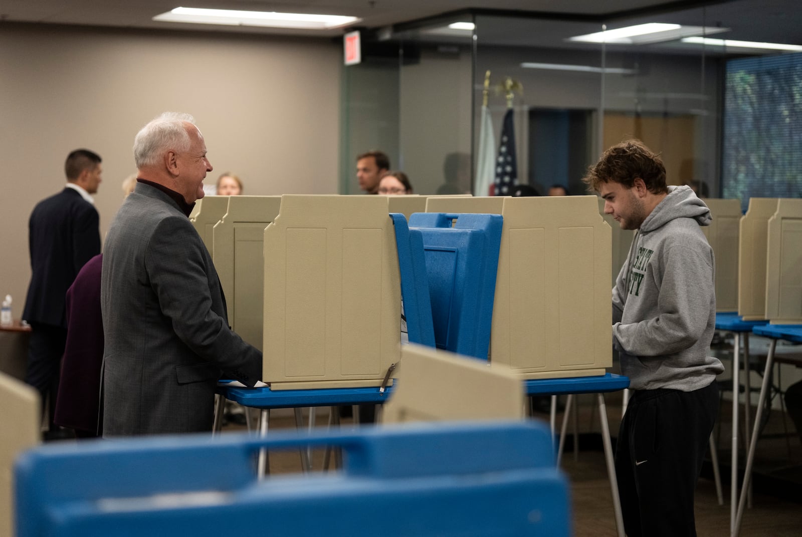 Minnesota Governor and Vice Presidential candidate Tim Walz, left, chats with his son, Gus Walz, a first time voter, as they cast their ballots during early voting at Ramsey County Elections in St. Paul, Minn., on Wednesday, October 23, 2024. (Renée Jones Schneider/Star Tribune via AP)