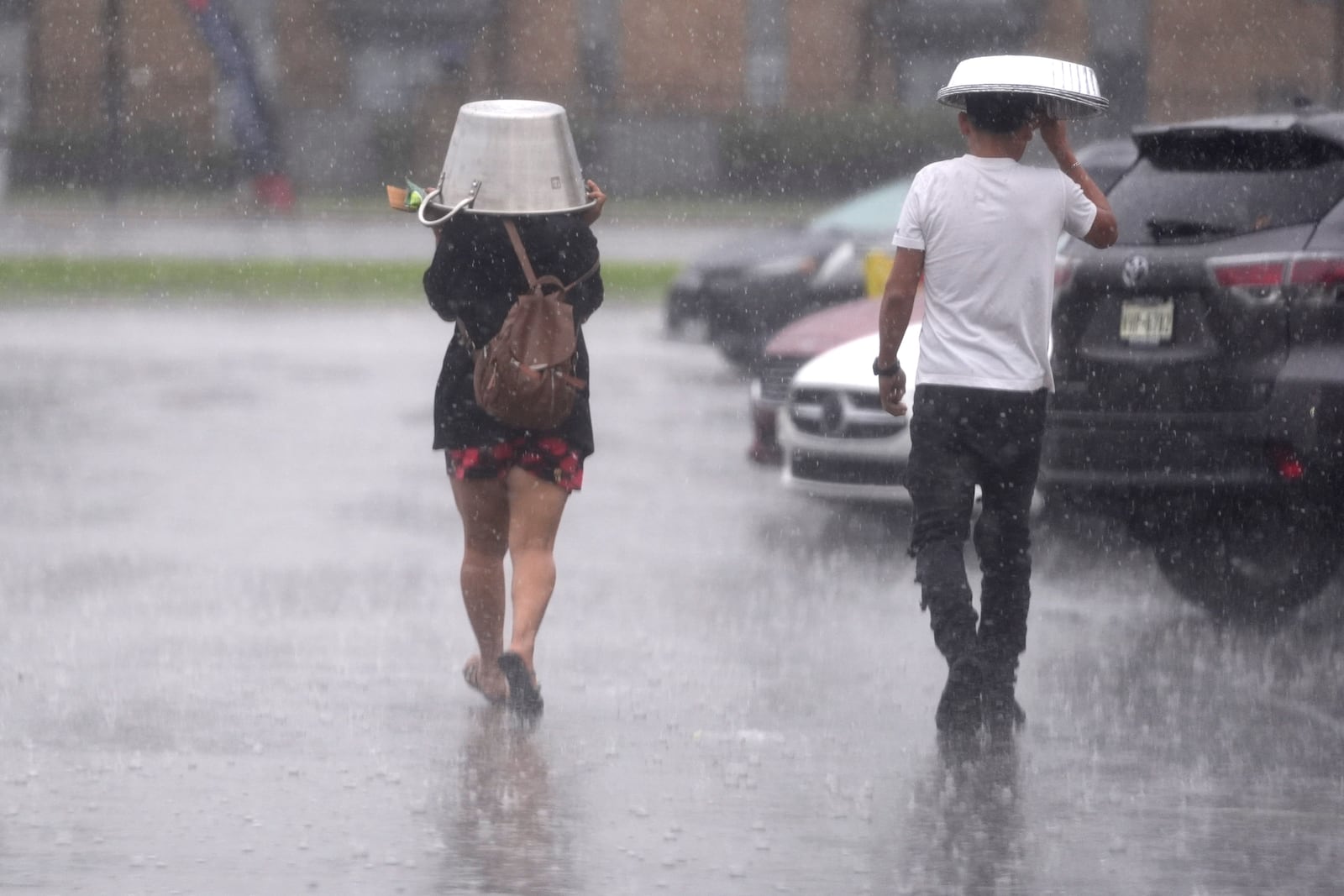 FILE - People cover up from falling rain Dec. 24, 2024, in Dallas. (AP Photo/LM Otero, File)