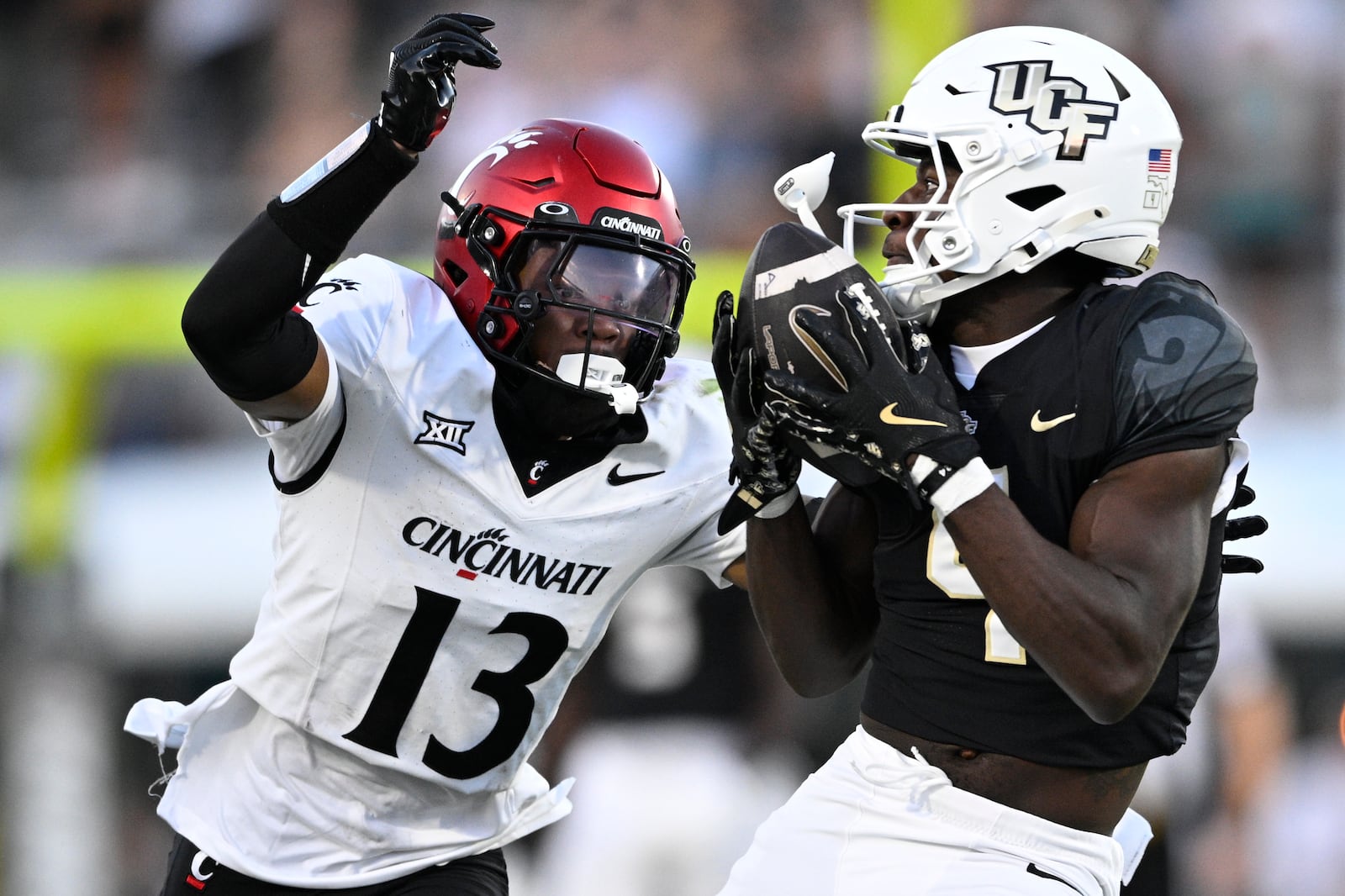 Central Florida wide receiver Chauncey Magwood, right, catches a pass as Cincinnati defensive back Logan Wilson (13) defends during the second half of an NCAA college football game, Saturday, Oct. 12, 2024, in Orlando, Fla. (AP Photo/Phelan M. Ebenhack)