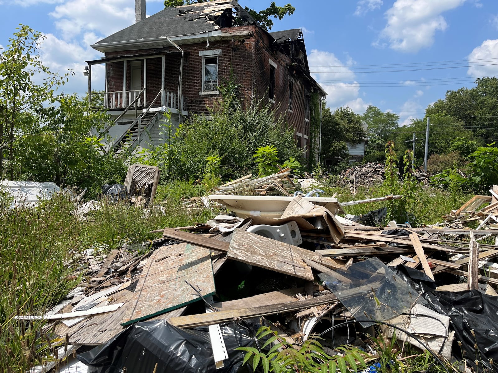 Debris and trash are still piled up on the site of a house fire on the 500 block of North Broadway Street in West Dayton. Five people were found dead after firefighters knocked down the blaze and were working at the site. CORNELIUS FROLIK / STAFF