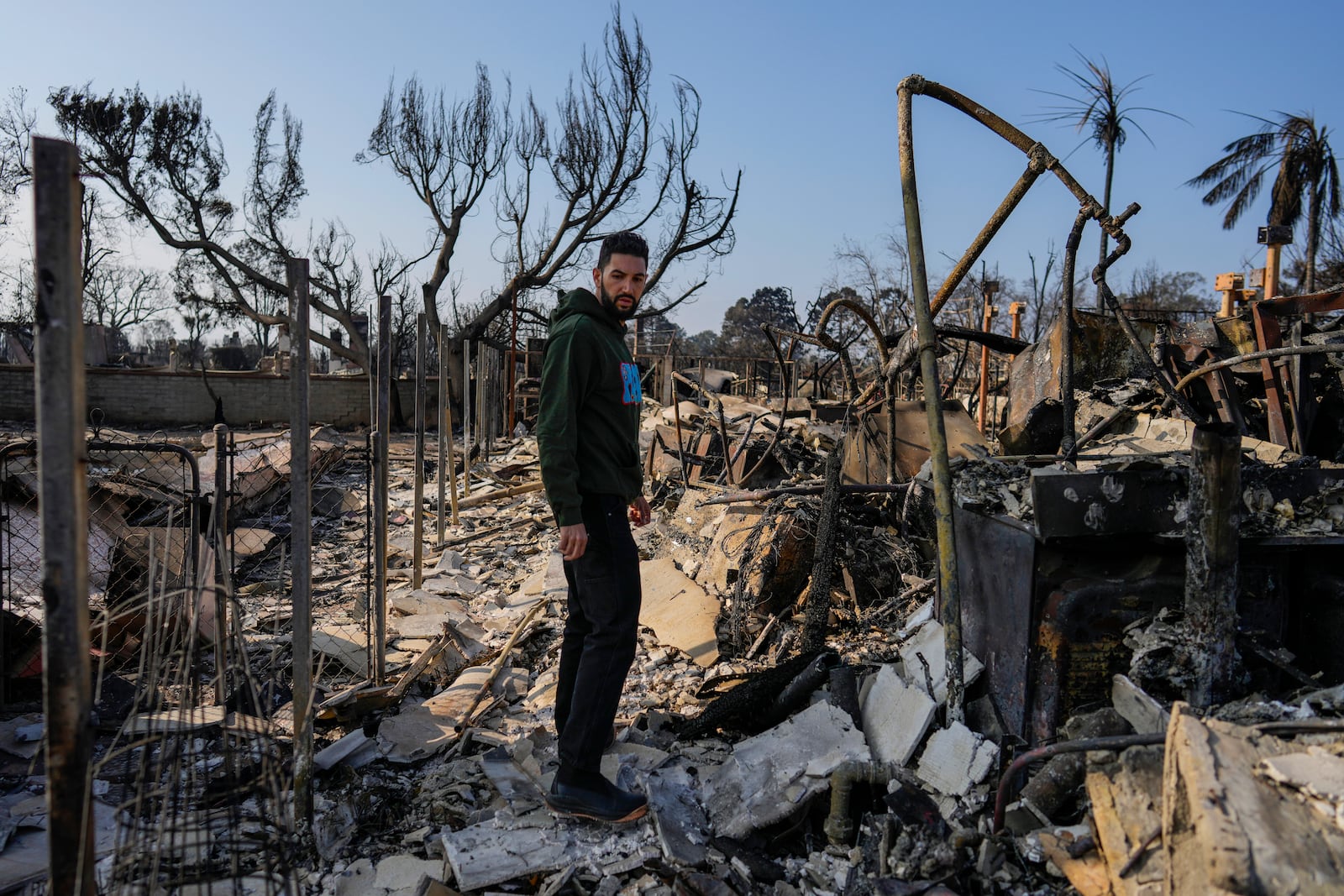 World Central Kitchen Chef Corp member Daniel Shemtob pauses as he walks through what remains of his home destroyed by the Palisades Fire, Sunday, Jan. 19, 2025, in the Pacific Palisades neighborhood of Los Angeles, Calif. (AP Photo/Carolyn Kaster)