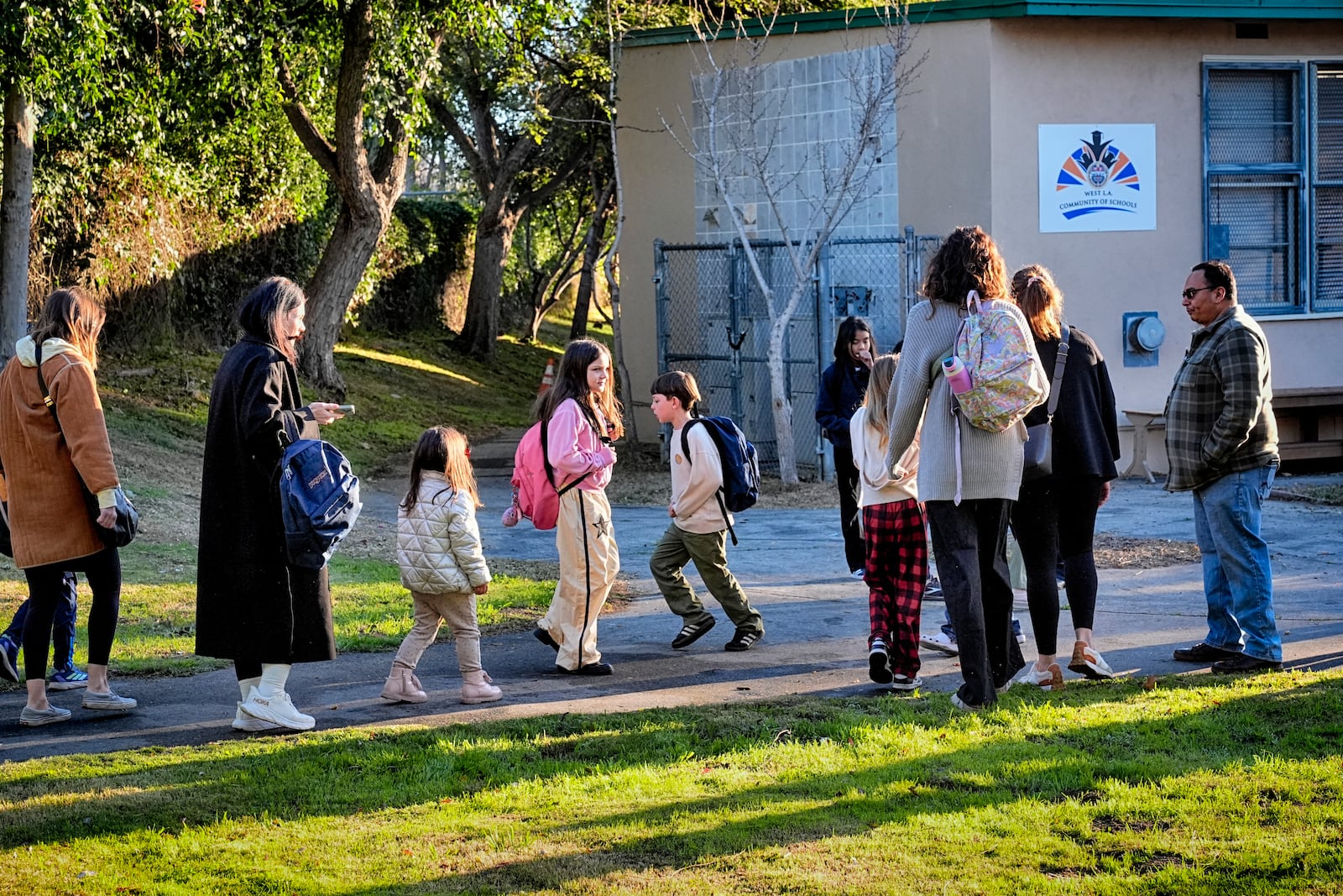 Palisades Charter Elementary School students and their parents arrive at their new school, the Brentwood Elementary Science Magnet school in the Brentwood section of Los Angeles on Wednesday, Jan. 15, 2025. (AP Photo/Richard Vogel)