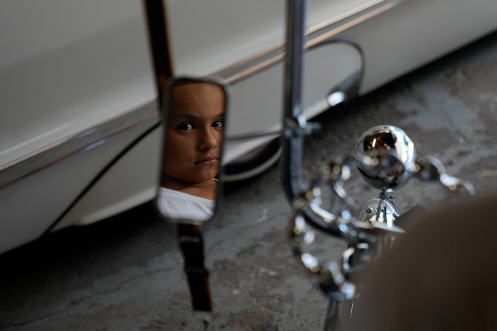 Daniel Marquez, 7. is reflected in the mirror of his chrome lowrider bike, built by himself and family friends in memory of his late father Alberto, a longtime member of lowrider car clubs, Saturday, Sept. 14, 2024, at his home in Frankfort, Ill. (AP Photo/Erin Hooley)