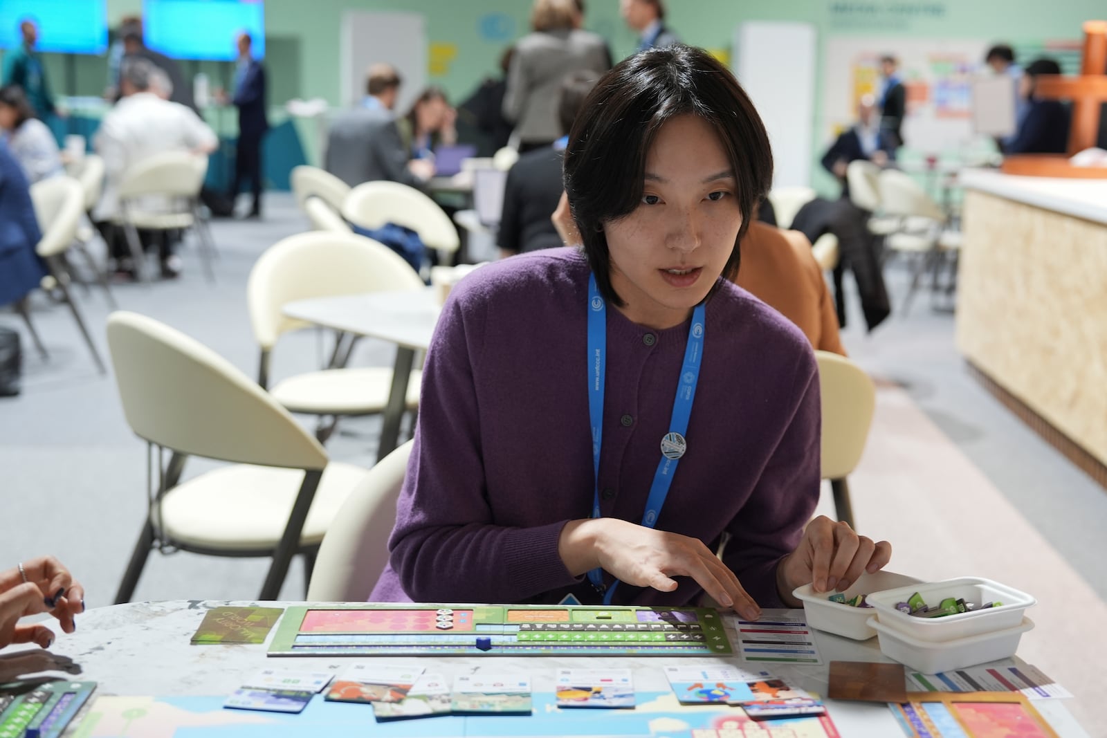 Yi Hyun Kim, of Solutions for Our Climate, plays Daybreak, a game where players are supposed to work together to find a way to curb climate change, at the COP29 U.N. Climate Summit, Tuesday, Nov. 19, 2024, in Baku, Azerbaijan. (AP Photo/Joshua A. Bickel)