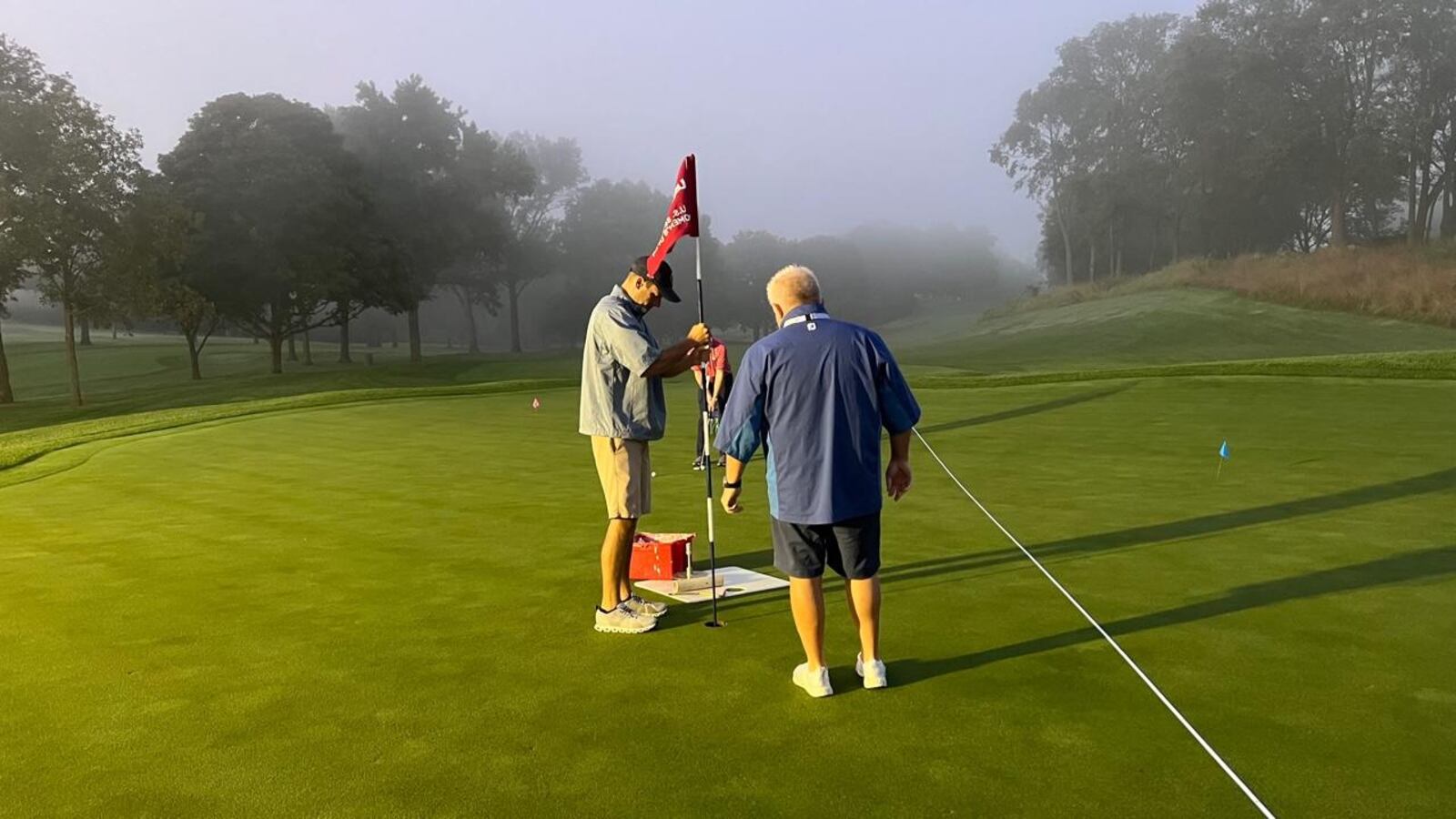 Steve Stockelman, (left) the assistant superintendent of the NCR North course,  and volunteer Jim Dillard from Columbus work on the ninth green on NCR’s South Course early Saturday morning before the start of the third round of the U.S. Senior Women’s Open Championship. Jim Campion/CONTRIBUTED