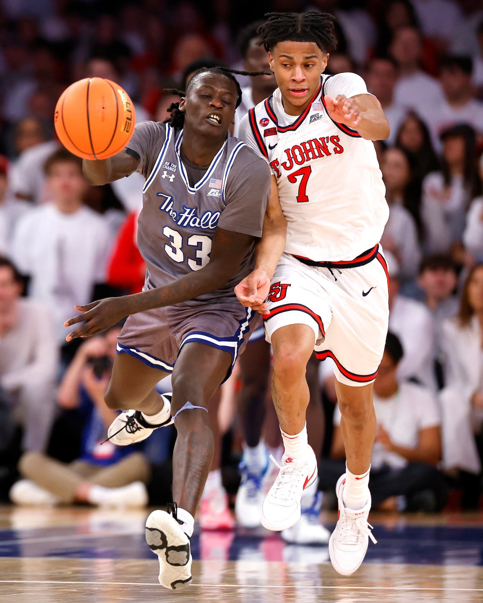 Seton Hall guard Garwey Dual (33) drives upcourt against St. John's guard Simeon Wilcher (7) during the first half of an NCAA college basketball game, Saturday, March 1, 2025, in New York. (AP Photo/Noah K. Murray)