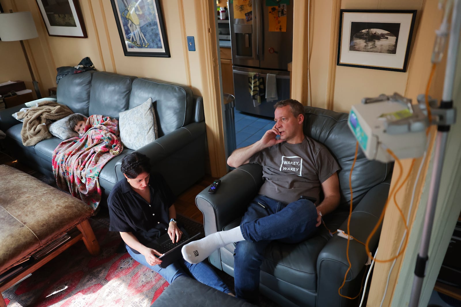 Jake Heinrichs watches television with his 3-year-old son, Sam, while his wife, Rachel Chavkin, works during his infusion treatment with an experimental anti-amyloid Alzheimer's drug in New York, on Wednesday, March 12, 2025. (AP Photo/Heather Khalifa)