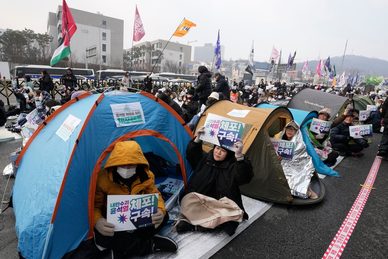 Protesters demanding the arrest of impeached South Korean President Yoon Suk Yeol attend a rally near the presidential residence in Seoul, South Korea, Monday, Jan. 6, 2025. The letters read "Arrest Yoon Suk Yeol." (AP Photo/Ahn Young-joon)