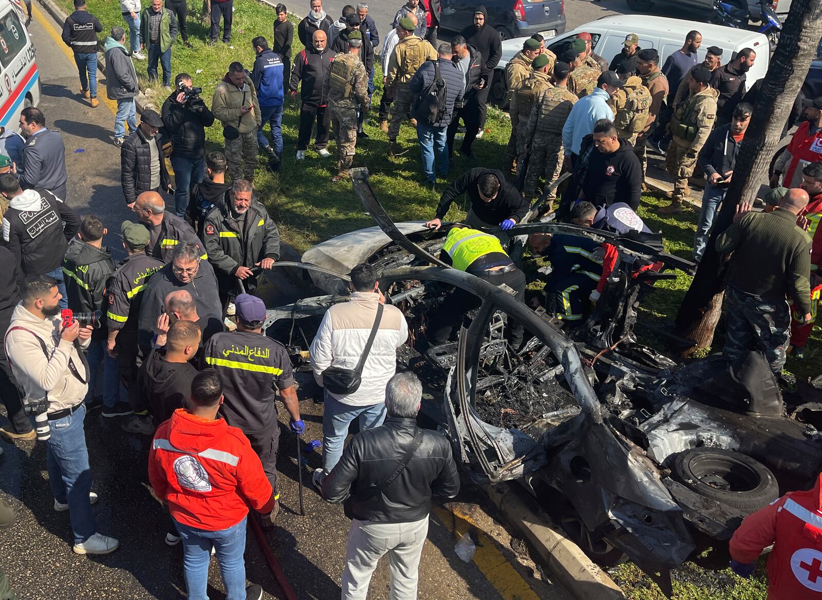 Civil defence workers and Lebanese soldiers gather next the remains of a burned car that was hit by an Israeli drone strike, in the southern port city of Sidon, Lebanon, Monday, Feb. 17, 2025.(AP Photo)