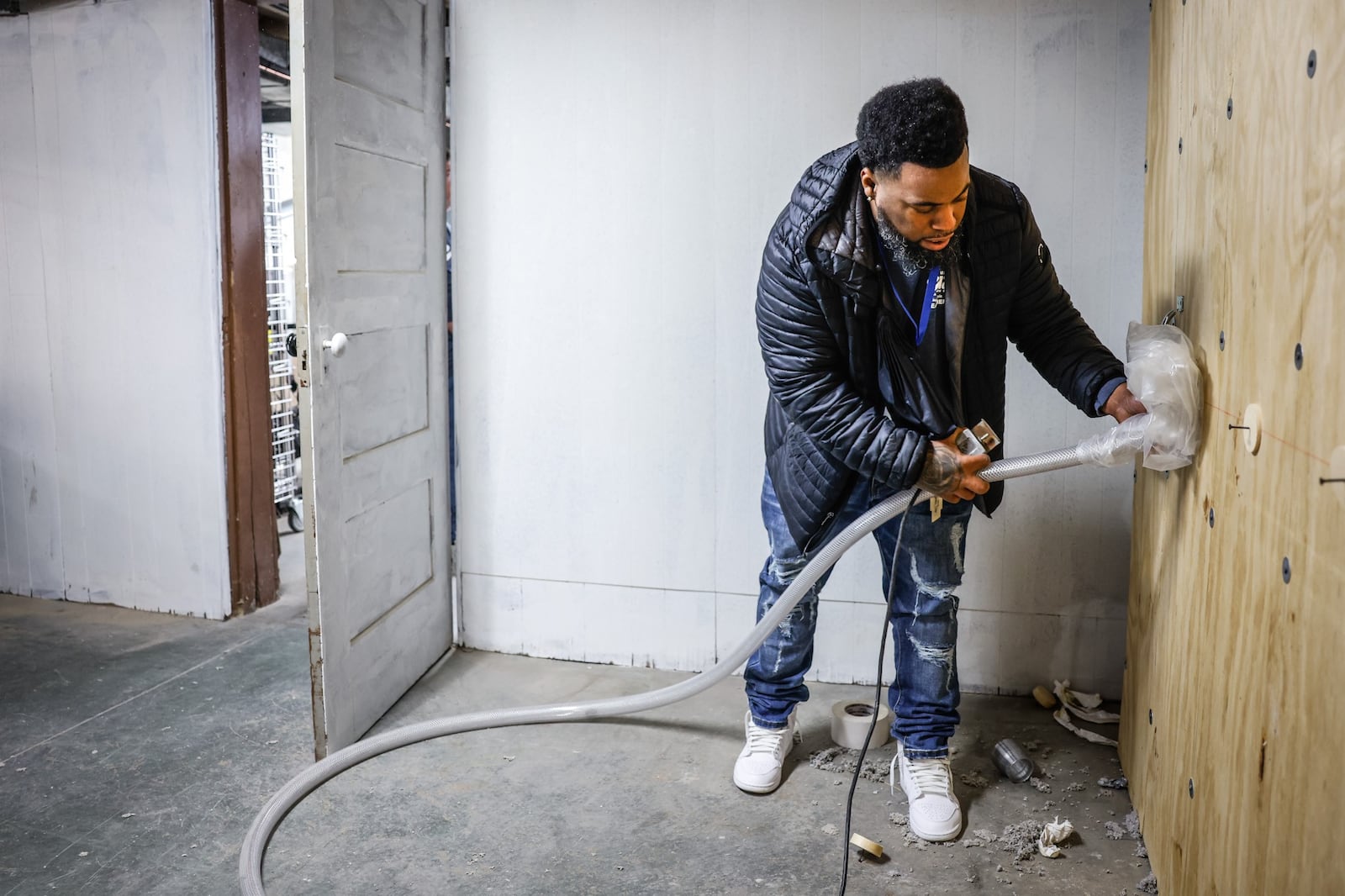 Nate Jones with the Miami Valley Community Action Partnership, demonstrates how insulation is sprayed into walls Friday, Oct. 28, 2022, at the partnership's new training center. JIM NOELKER/STAFF