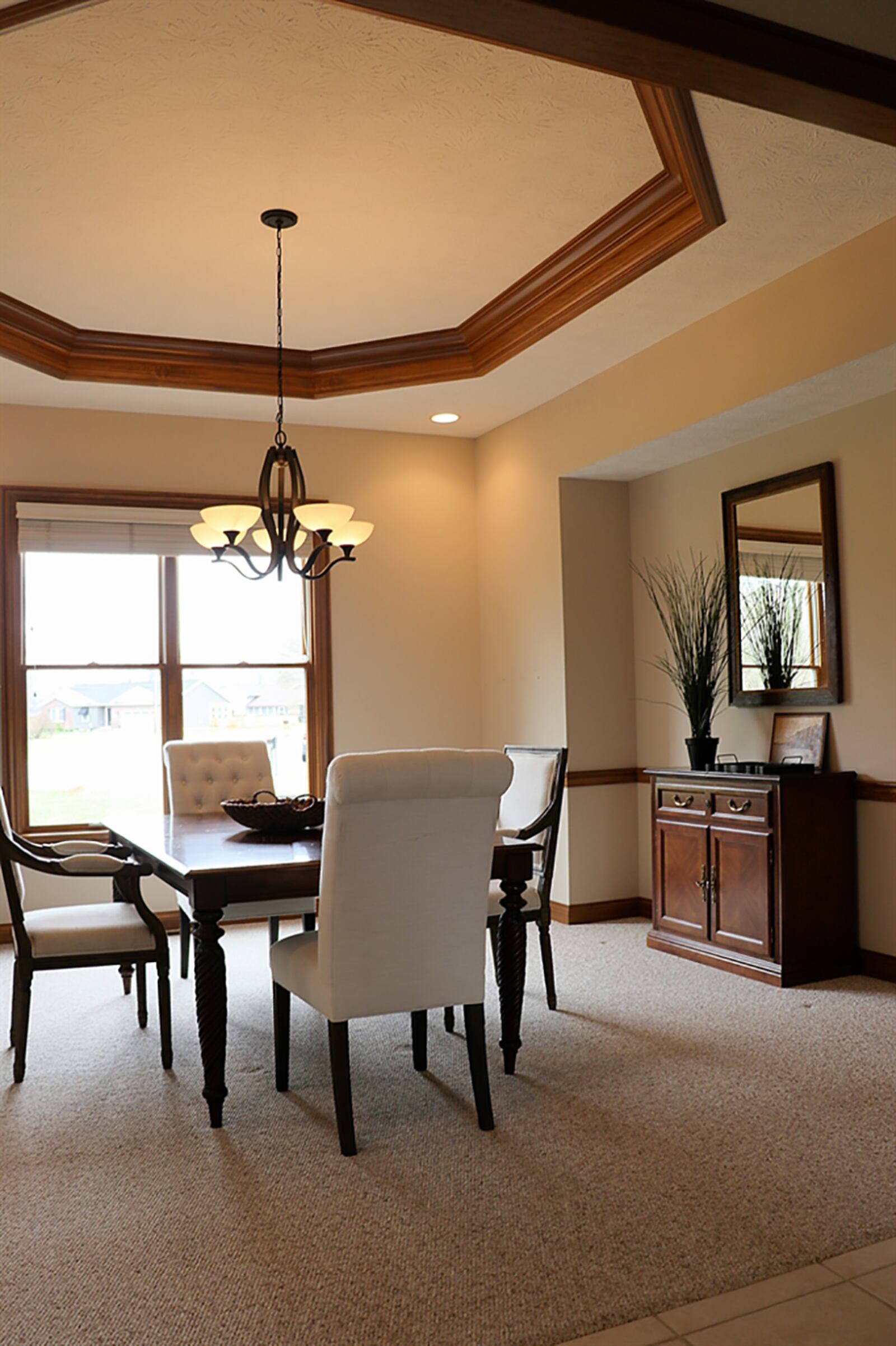 The formal dining room has a tray ceiling with wood trim accents and chair rail. The dining room is accessible from the foyer and the central hallway. CONTRIBUTED PHOTO BY KATHY TYLER