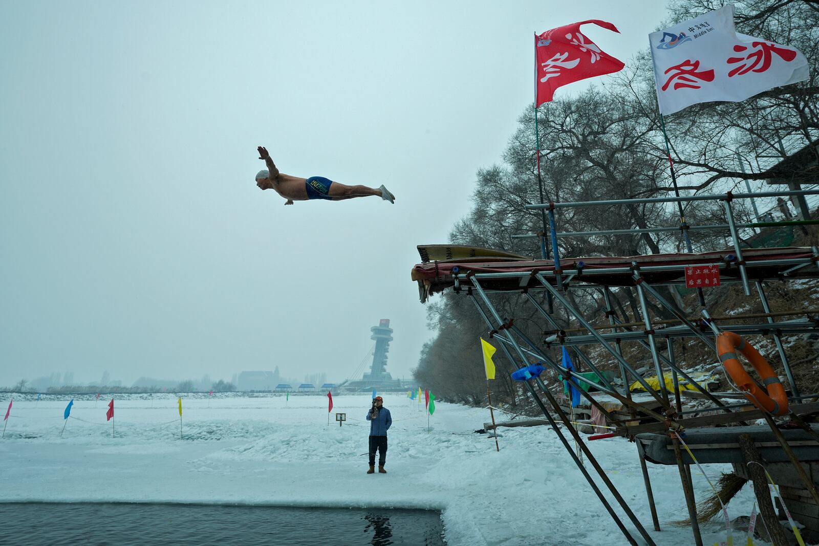 A man jumps into a pool carved from ice on the frozen Songhua river in Harbin in northeastern China's Heilongjiang province, Tuesday, Jan. 7, 2025. (AP Photo/Andy Wong)