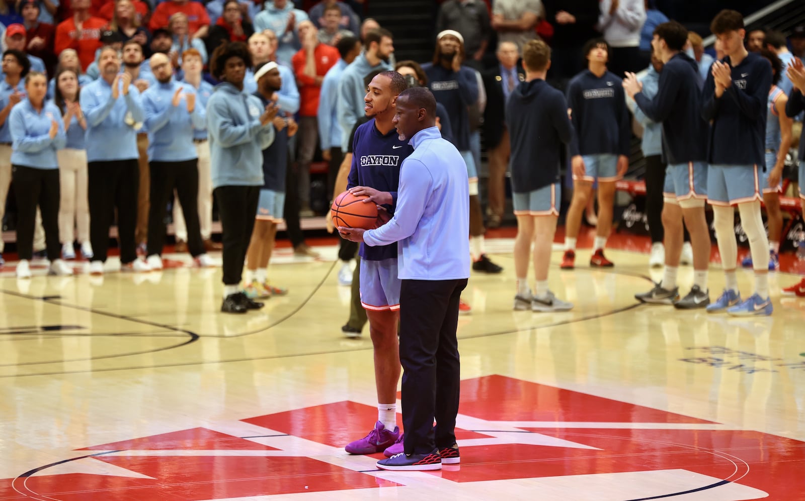 Dayton's Zed Key is honored by Anthony Grant for scoring 1,000 points in his career before a game against Marquette on Saturday, Dec. 14, 2024, at UD Arena. David Jablonski/Staff