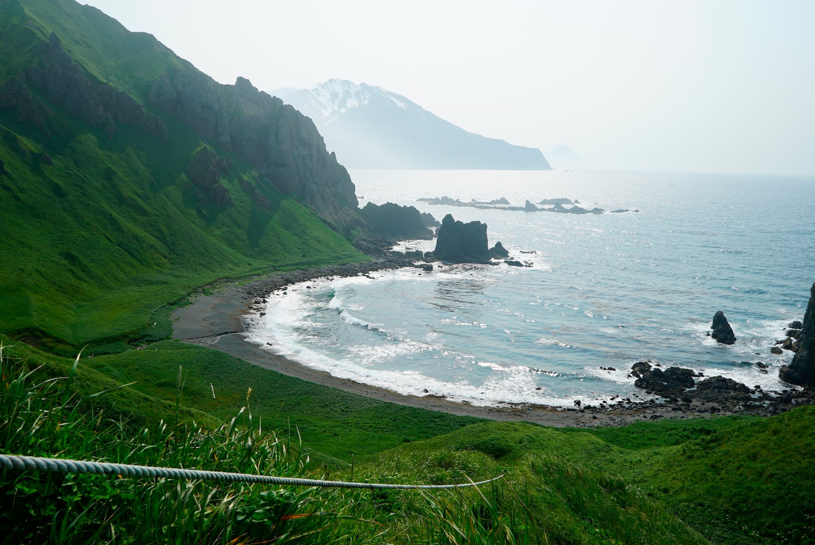 FILE - A rope is mounted cliffside at Horseshoe Bay that assists climbers in descending to the shore and nearby hot springs below on Adak Island, Alaska. (Nicole Evatt via AP, File)