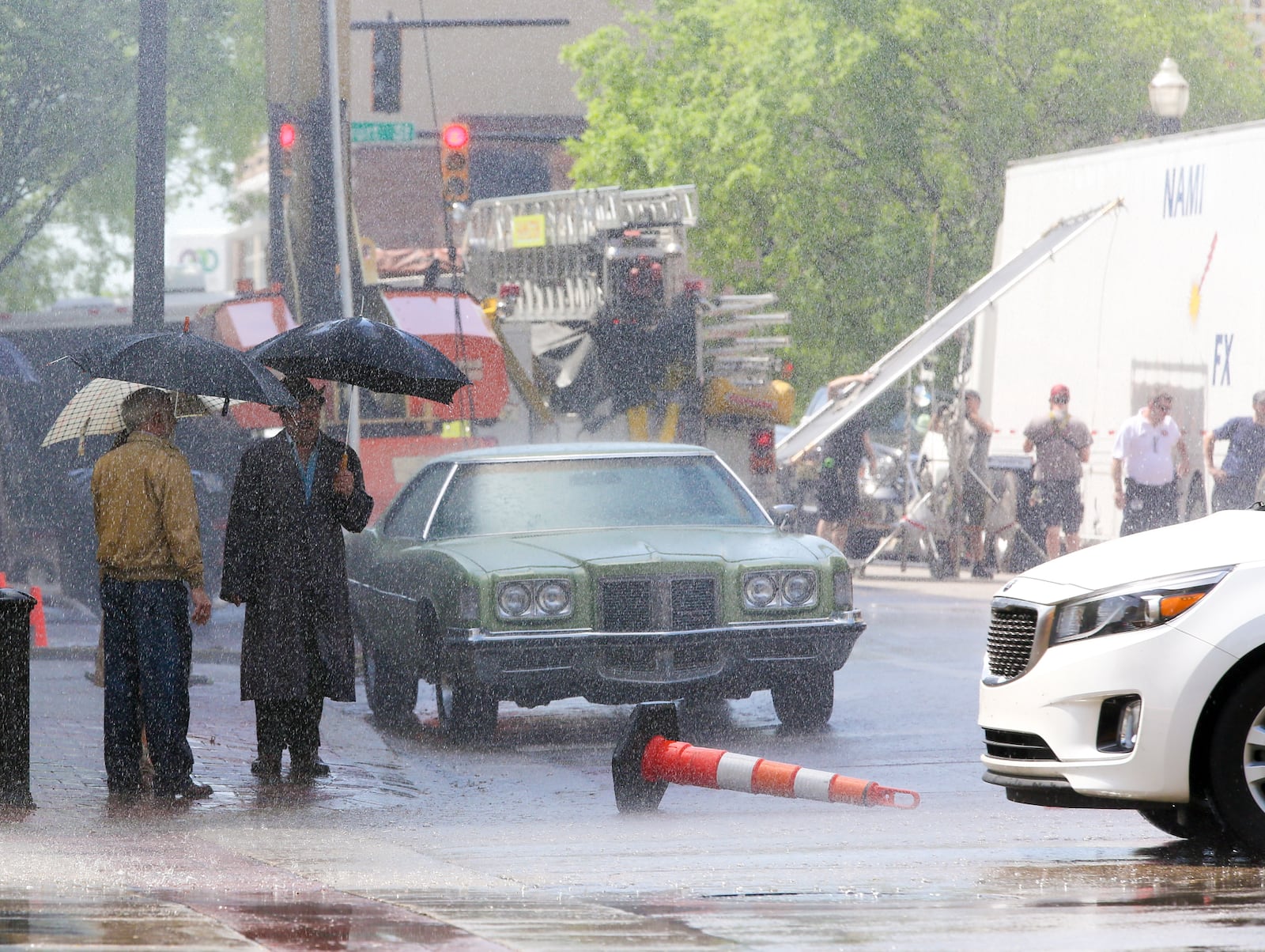 Scenes like these will be coming to Dayton next week for production of the Robert Redford movie, Old Man and the Gun. Crews were in Hamilton last week, seen here creating fake rain at the Fifth Third Bank building for scenes on Wednesday. GREG LYNCH / STAFF