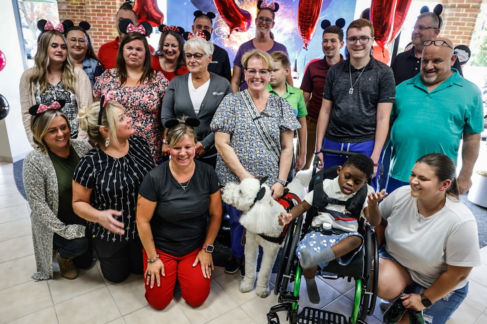 The Fisher family of Moraine and River Valley Credit Union employees pose for a group photograph after the family received the 1,900th gift from A Special Wish Foundation of Southwest Ohio on Wednesday, Sept. 4, 2024. The Fishers are planning for a trip to Walt Disney World in Florida. JIM NOELKER/STAFF