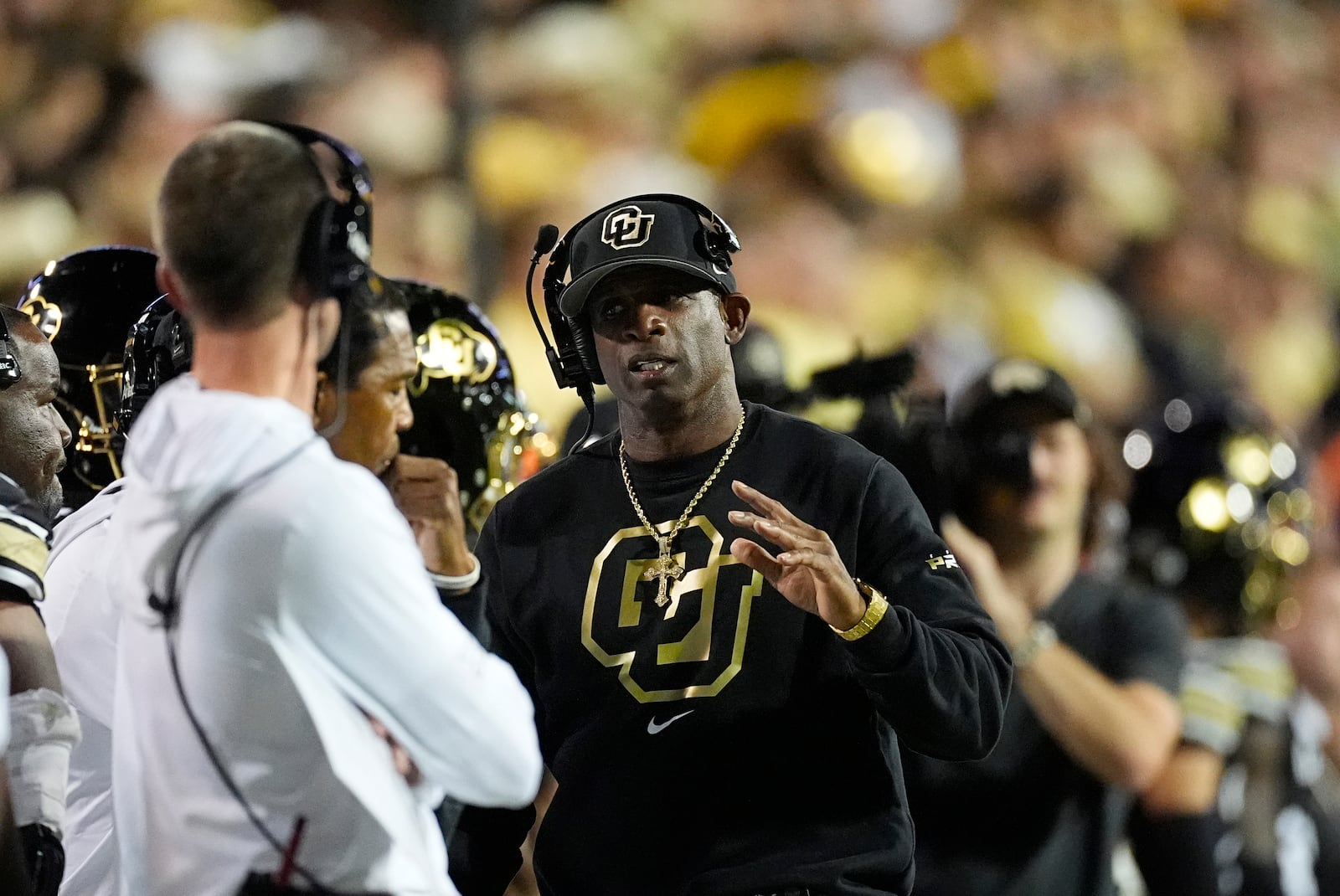 Colorado head coach Deion Sanders talks to assistant coaches in the second half of an NCAA college football game against Kansas State Saturday, Oct. 12, 2024, in Boulder, Colo. (AP Photo/David Zalubowski)