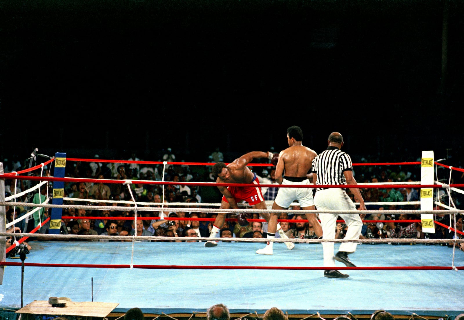 FILE - Challenger Muhammad Ali watches as defending world champion George Foreman struggles to keep his balance during the WBA/WBC championship bout in Kinshasa, Zaire, on Oct. 30, 1974. (AP Photo, File)