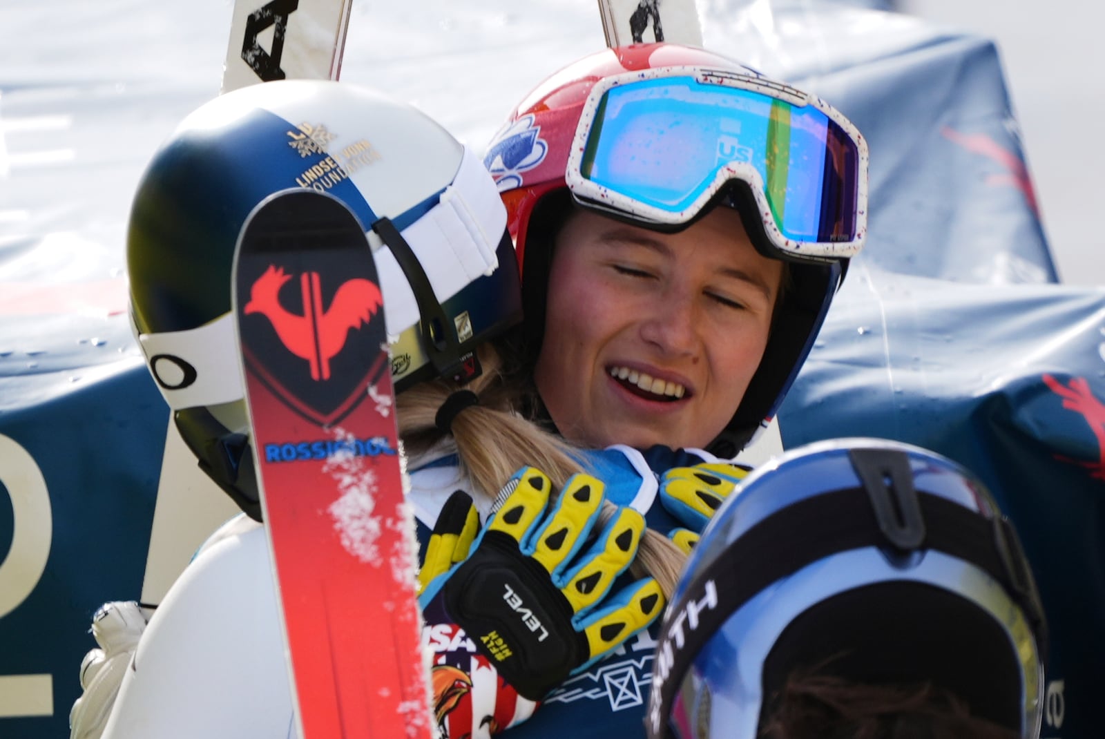 United States' Lindsey Vonn, left with back to camera, hugs United States' Lauren Macuga at the finish area of a downhill run of a women's team combined event, at the Alpine Ski World Championships, in Saalbach-Hinterglemm, Austria, Tuesday, Feb. 11, 2025. (AP Photo/Giovanni Auletta)