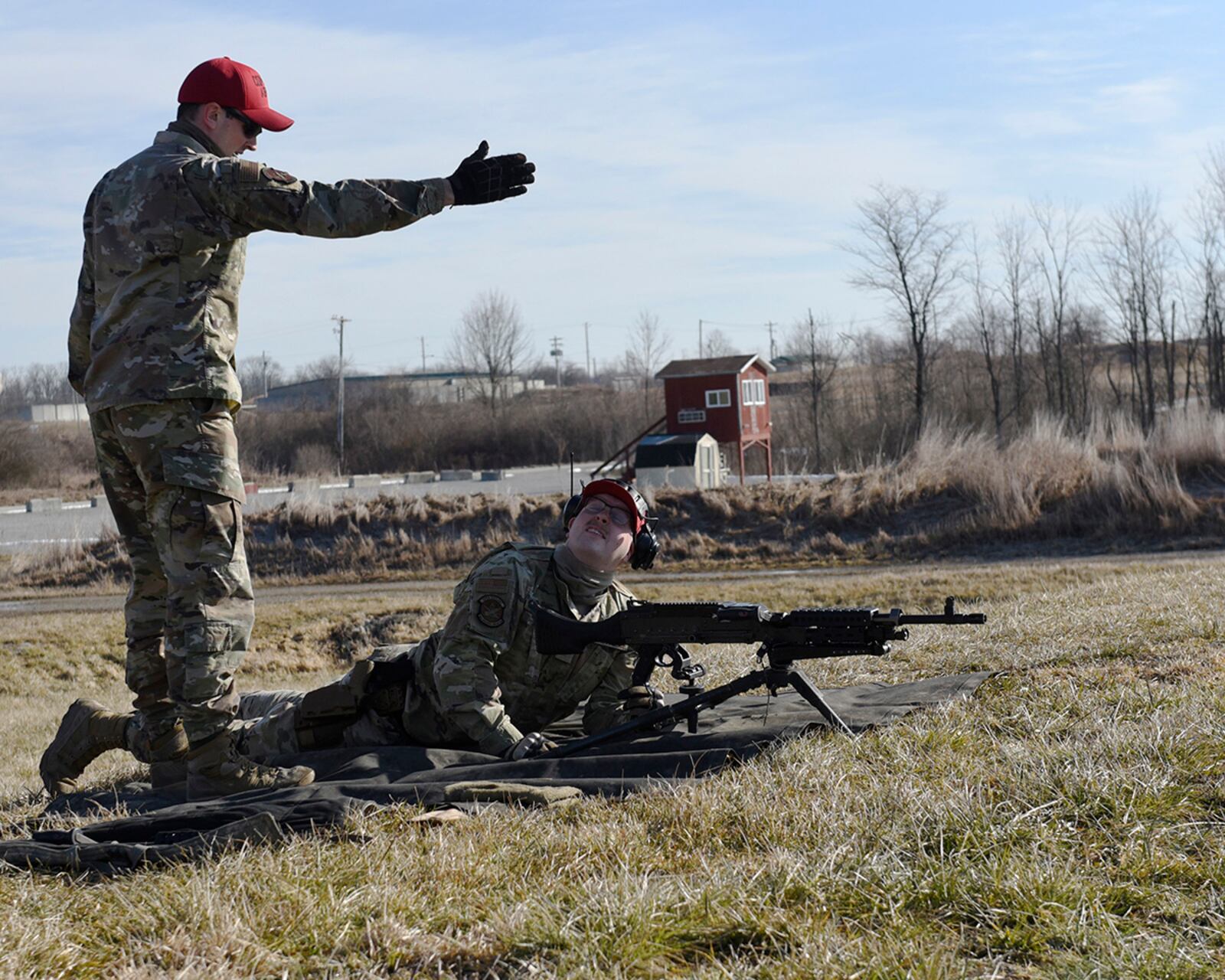 Staff Sgt. Sawyer McIntyre (left) and Senior Airman Clayton Nyp, both 88th Security Forces Squadron combat-arms instructors, discuss sighting an M240B machine gun at Camp Atterbury, Indiana, on Feb. 25. U.S. AIR FORCE PHOTO/TY GREENLEES