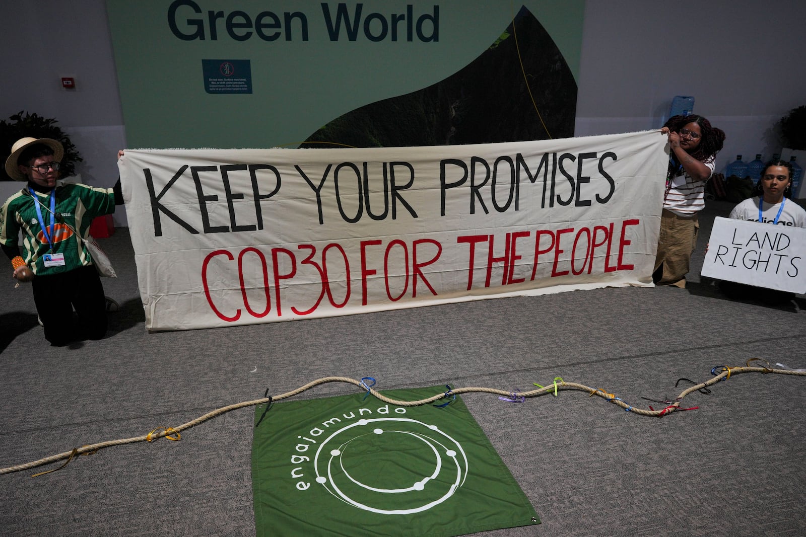 People demonstrate with a sign that reads "keep your promises COP39 for the people" at the COP29 U.N. Climate Summit, Saturday, Nov. 16, 2024, in Baku, Azerbaijan. (AP Photo/Peter Dejong)