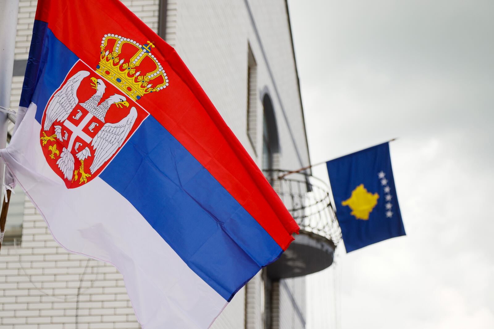 FILE - The Serbian flag, left, flies on a lamppost in front of a Kosovo flag on the city hall in the town of Zubin Potok, northern Kosovo, May 31, 2023. (AP Photo/Marjan Vucetic, File)