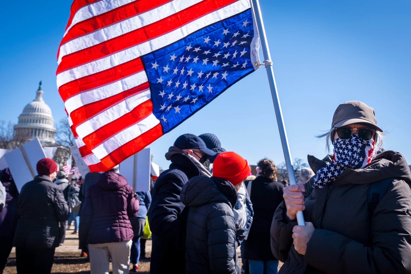 A federal employee who asked not to be named holds an U.S. flag that she flew upside down "as a sign of distress," during the "No Kings Day" protest on Presidents Day in Washington, in support of federal workers and against recent actions by President Donald Trump and Elon Musk, Monday, Feb. 17, 2025, by the Capitol in Washington. The protest was organized by the 50501 Movement, which stands for 50 Protests 50 States 1 Movement. (AP Photo/Jacquelyn Martin)