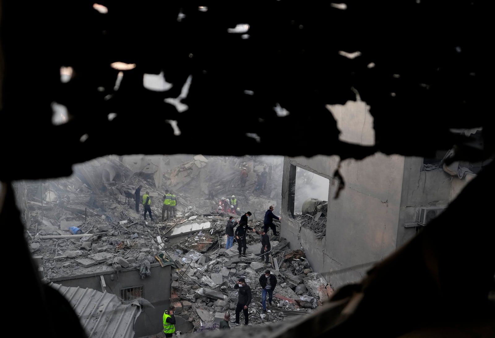 Rescue workers and people search for victims at the site of an Israeli airstrike that hit central Beirut, Lebanon, Saturday, Nov. 23, 2024. (AP Photo/Hassan Ammar)