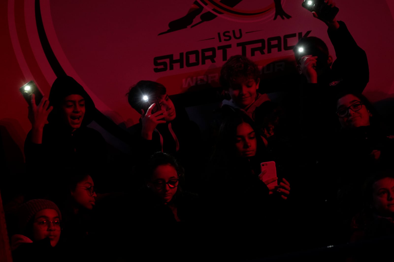 Spectators light smartphone torches during preliminaries round of the ISU Short Track World Tour, Olympics Milano-Cortina 2026 test event, in Milan, Italy, Friday, Feb. 14, 2025. (AP Photo/Luca Bruno)