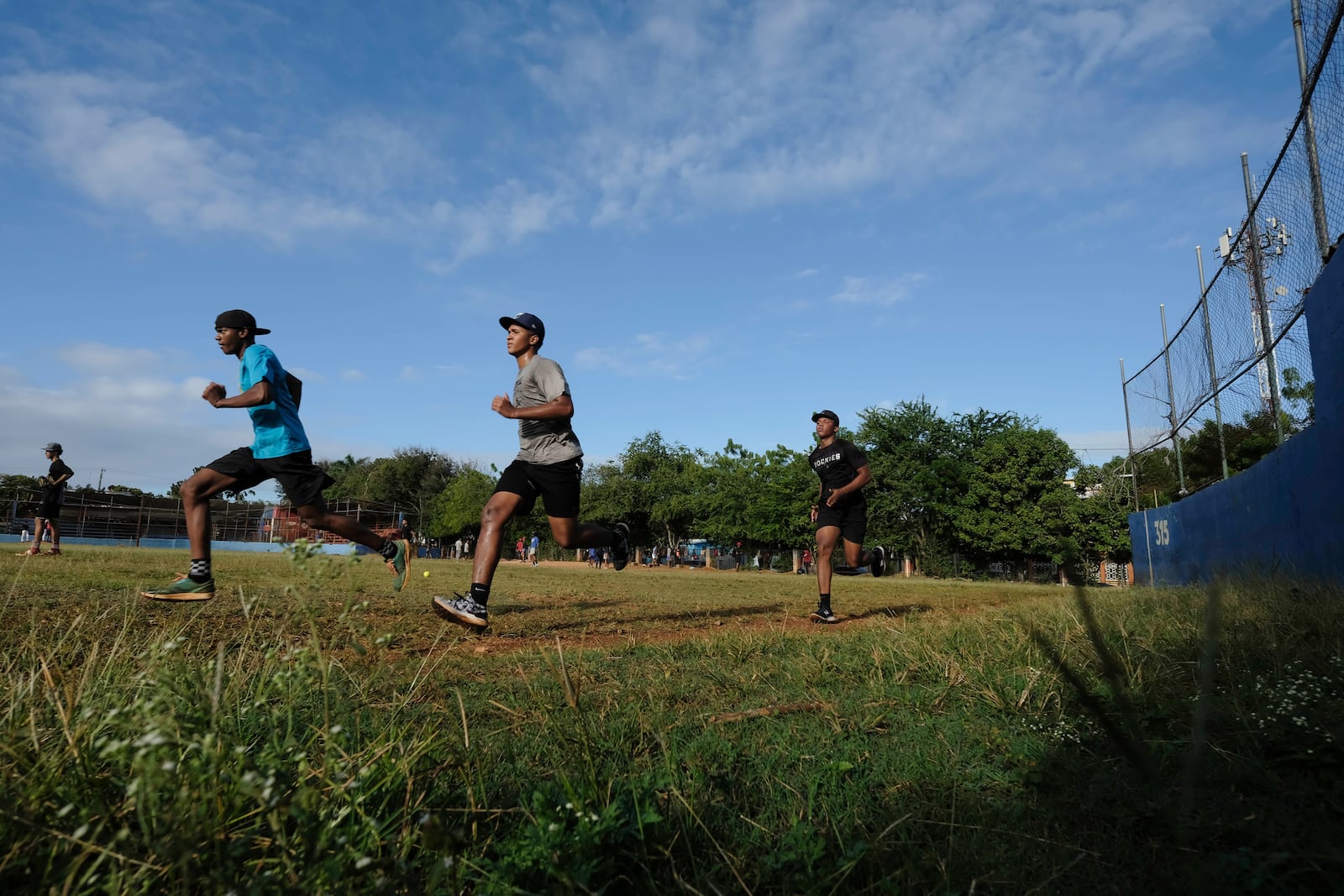 Teenage baseball players run laps during their daily training session at the Trinitarios ballpark in Santo Domingo, Dominican Republic, Wednesday, Feb. 5, 2025. (AP Photo/Ricardo Hernandez)