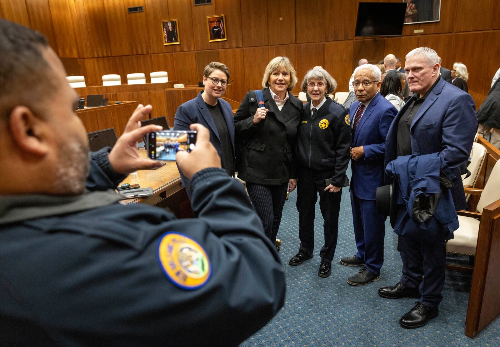 New Orleans Police Superintendent Anne Kirkpatrick, center of group, poses for photos with U.S. Justice Department lawyers, left, and deputy monitor David Douglass, right center, as she leaves Federal Court, Tuesday, Jan. 14, 2025, in New Orleans, after a judge ruled the New Orleans Police Department can begin the process of ending longstanding federal oversight. (Chris Granger/The Times-Picayune/The New Orleans Advocate via AP)