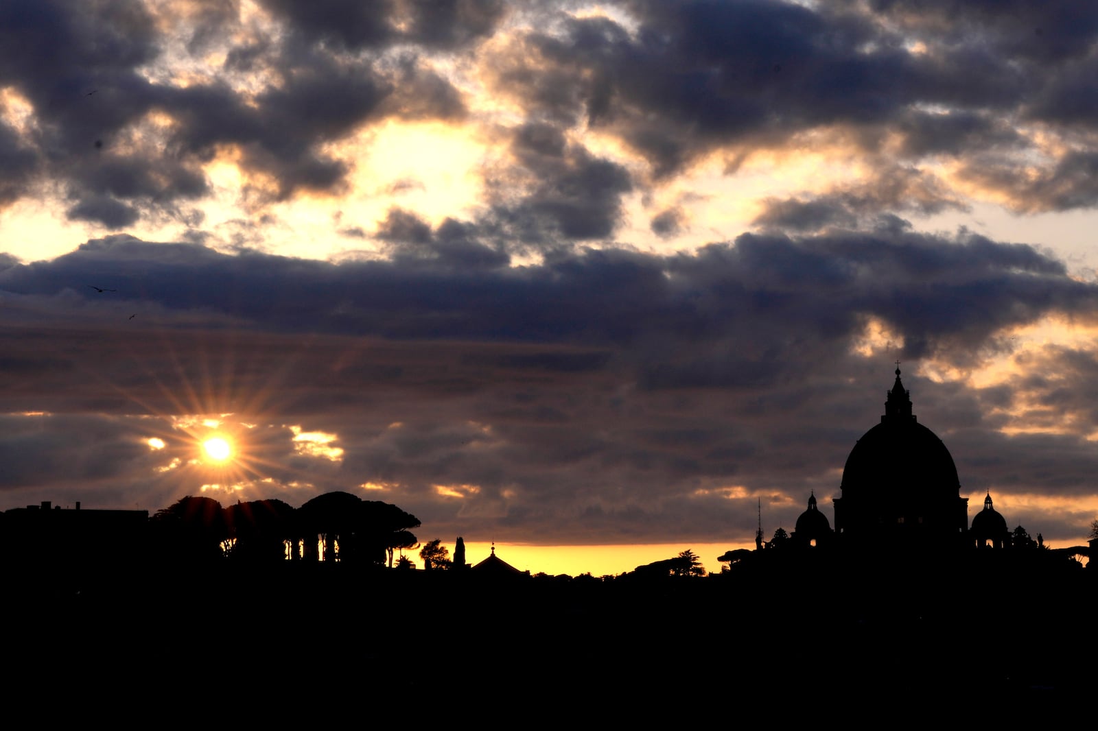 Dark clouds hover over St Peter's Basilica at the Vatican in Rome, Sunday, March 2, 2025. (AP Photo/Kirsty Wigglesworth)