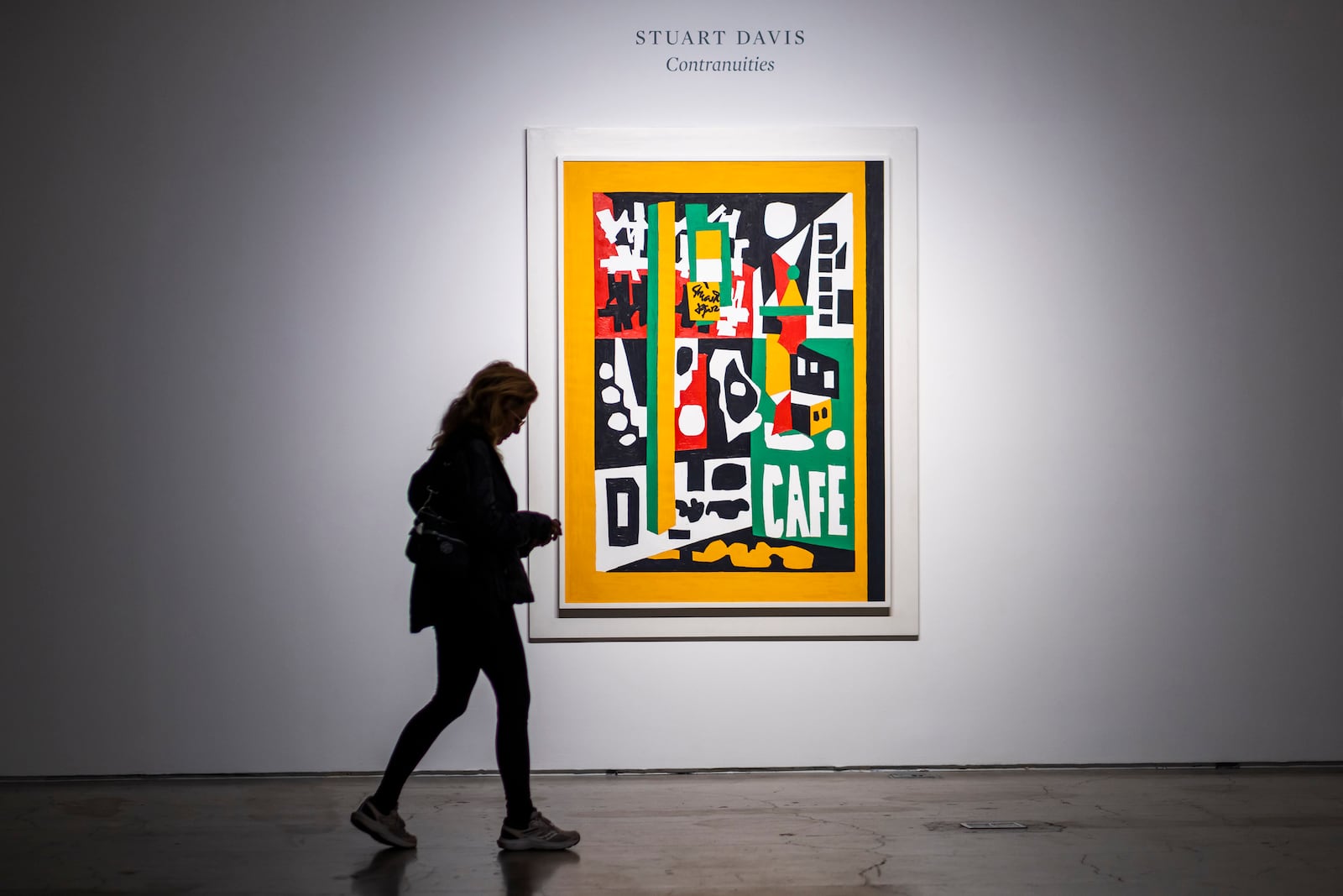 A woman walks near "Contranuities," by Stuart Davis, during an auction preview at Sotheby's in New York, Monday, Nov. 11, 2024. (AP Photo/Eduardo Munoz Alvarez)