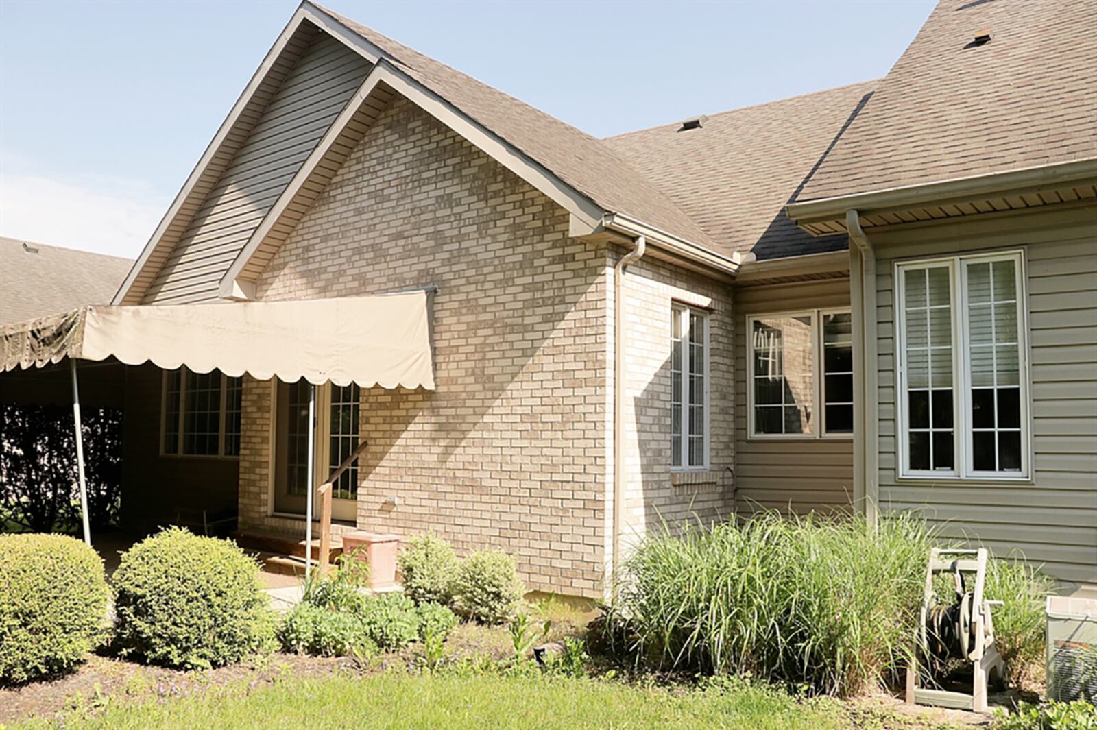 French patio doors open to a backyard patio. The back yard is private with vinyl privacy fences and mature gardens. CONTRIBUTED PHOTO BY KATHY TYLER