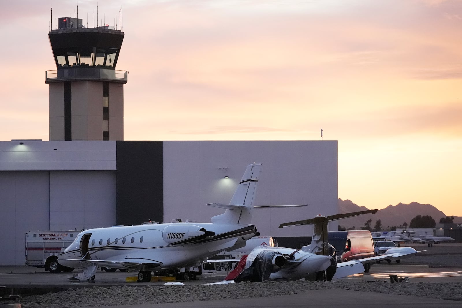 A damaged Learjet, right, sits damaged after colliding with a parked jet at Scottsdale Airport Monday, Feb. 10, 2025, in Scottsdale, Ariz. (AP Photo/Ross D. Franklin)