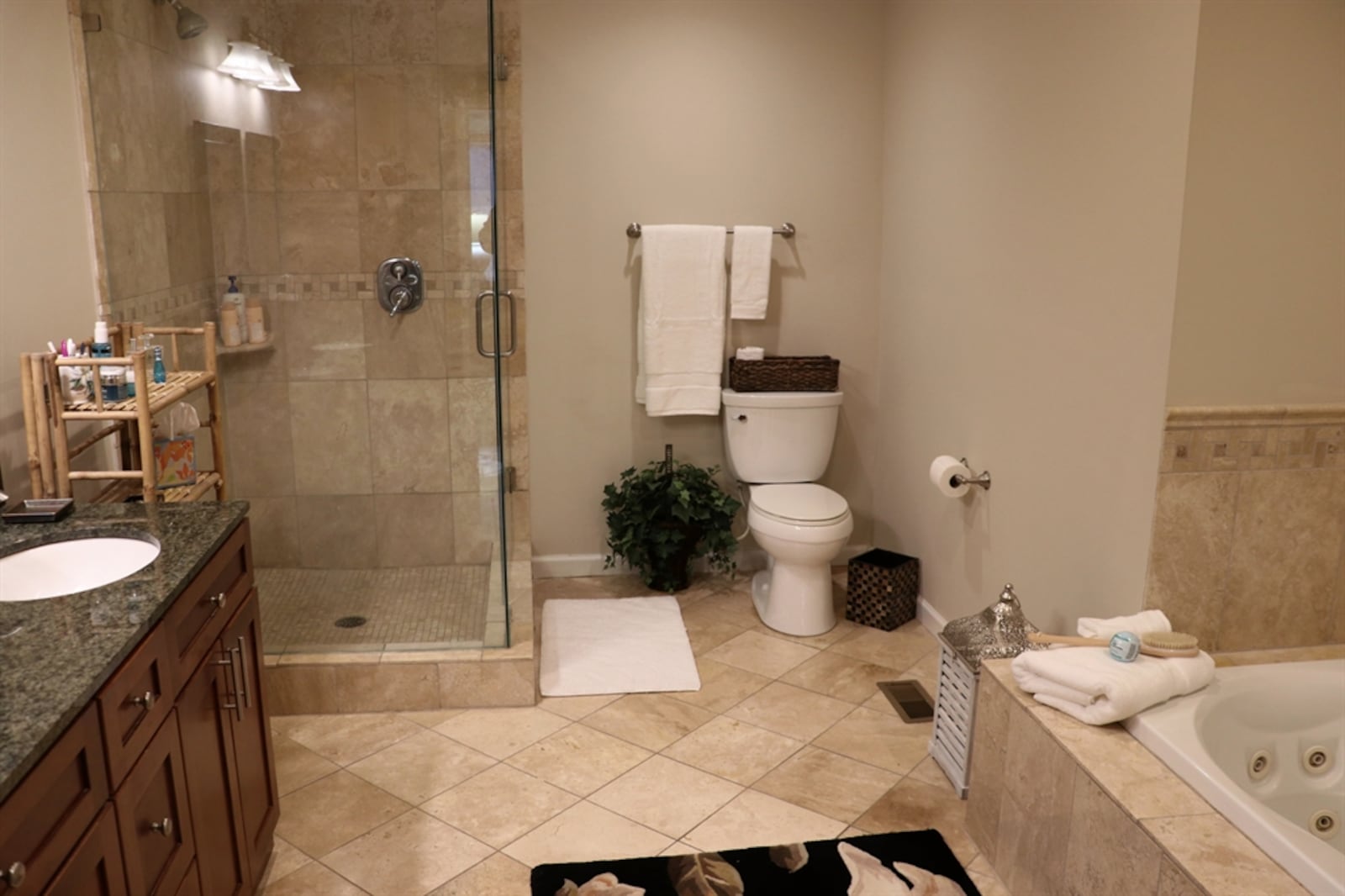 The primary bathroom has been updated with a walk-in shower with ceramic-tile surround, glass doors and dual shower heads.