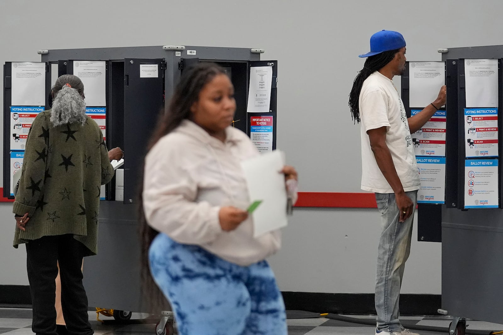 C.T. Martin, right, casts his ballot, Tuesday, Nov. 5, 2024, in Atlanta. (AP Photo/Brynn Anderson)