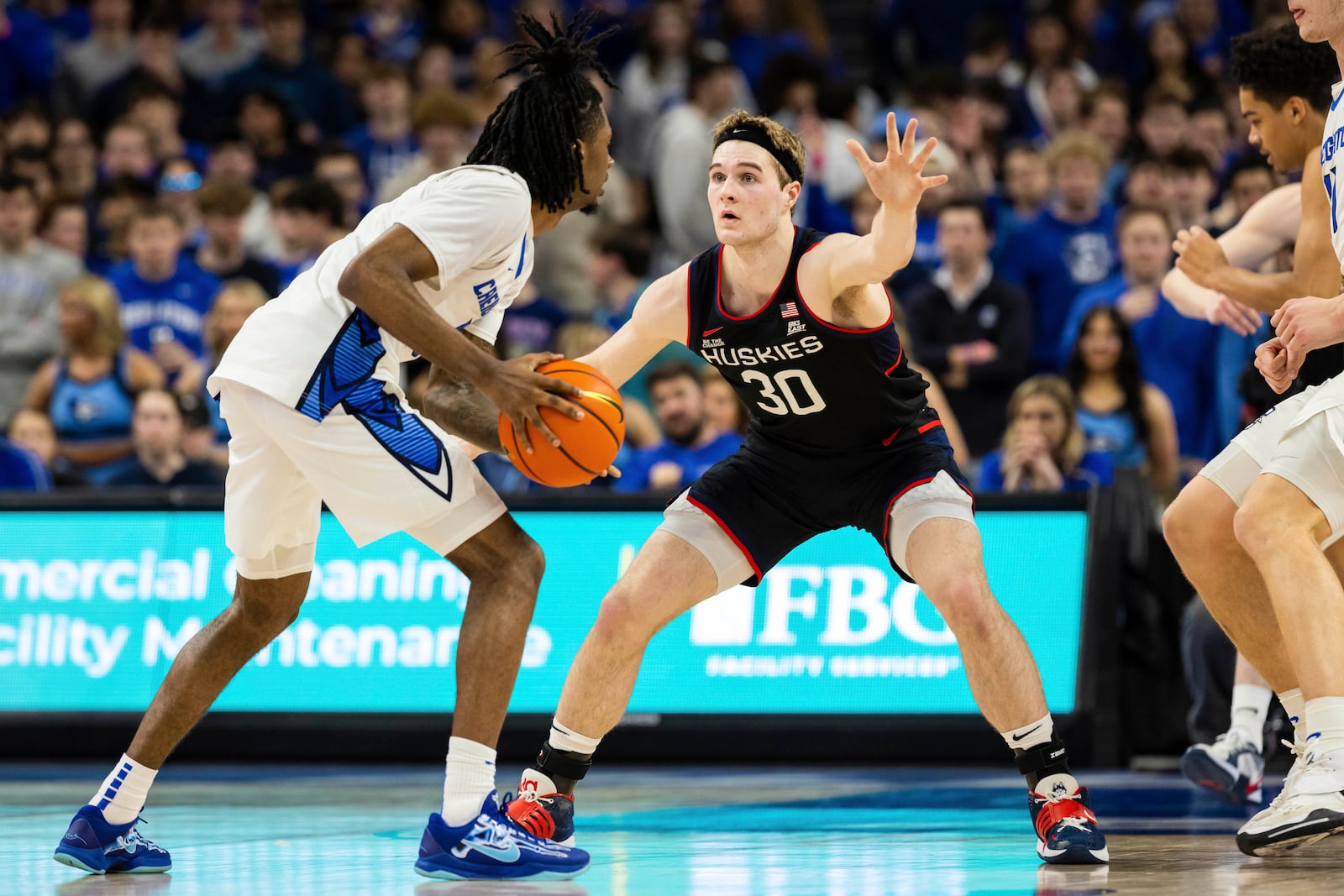 UConn forward Liam McNeeley (30) guards against Creighton guard Jamiya Neal (5) during the first half of an NCAA college basketball game, Tuesday, Feb. 11, 2025, in Omaha, Neb. (AP Photo/Bonnie Ryan)