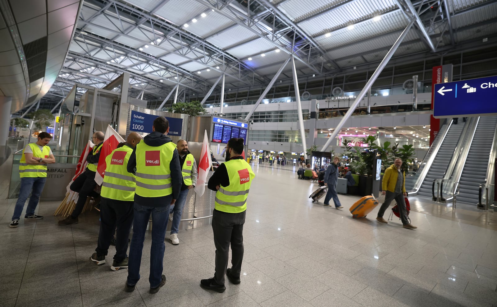 Striking members of the Verdi union stand in the departure area of the terminal building at Dusseldorf Airport, Germany Monday, March 10, 2025. (Christoph Reichwein/dpa via AP)