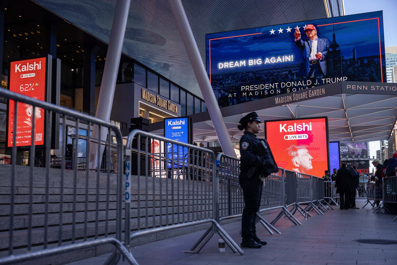 A police officer stands in front of the campaign video boards for Republican presidential nominee former President Donald Trump outside Madison Square Garden, Sunday, Oct. 27, 2024, in New York. (AP Photo/Yuki Iwamura)