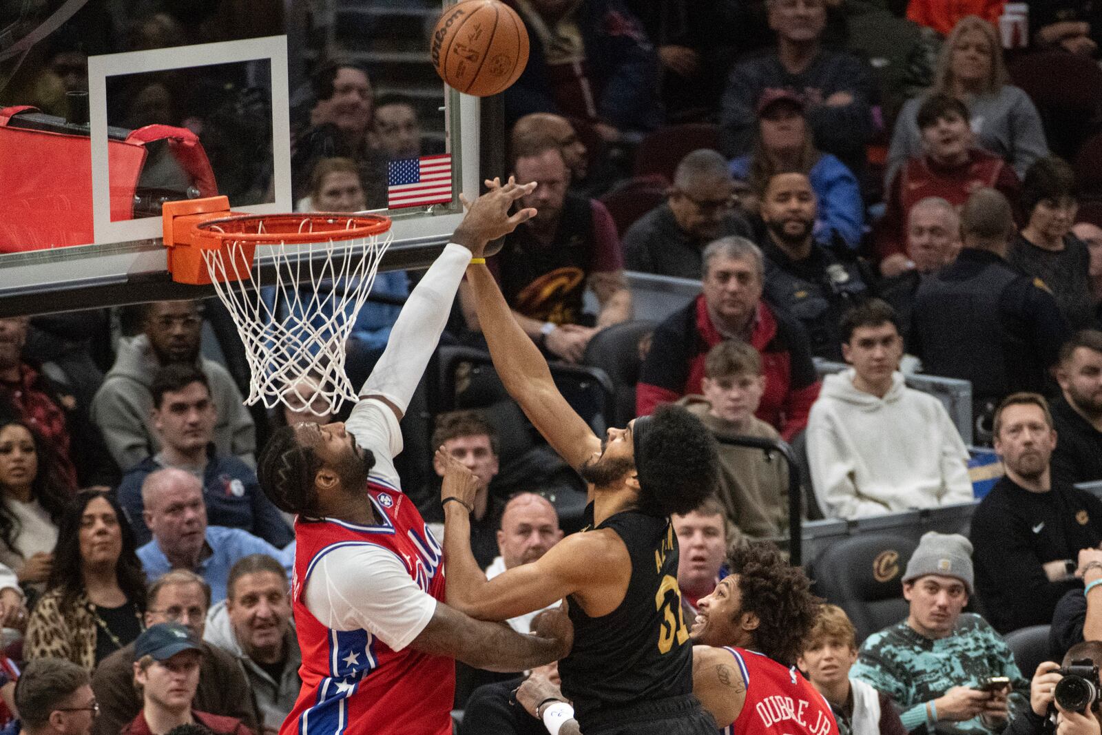 Philadelphia 76ers' Andre Drummond, left blocks a shot by Cleveland Cavaliers' Jarrett Allen, right, during the first half of an NBA basketball game in Cleveland, Saturday Dec. 21, 2024. (AP Photo/Phil Long)