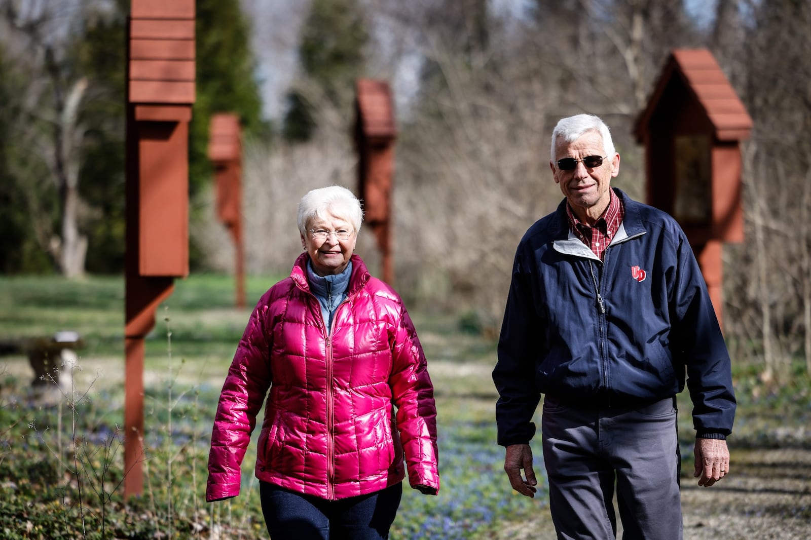 Bill and Angie Platfoot walk on trails that circle the Lange Estate, which is home to the Transfiguration Center for Spiritual Renewal. The wooden structures, in the background, that line the paths are the way of the Cross that depicts the journey of Jesus to the place of his crucifixion.   JIM NOELKER/STAFF