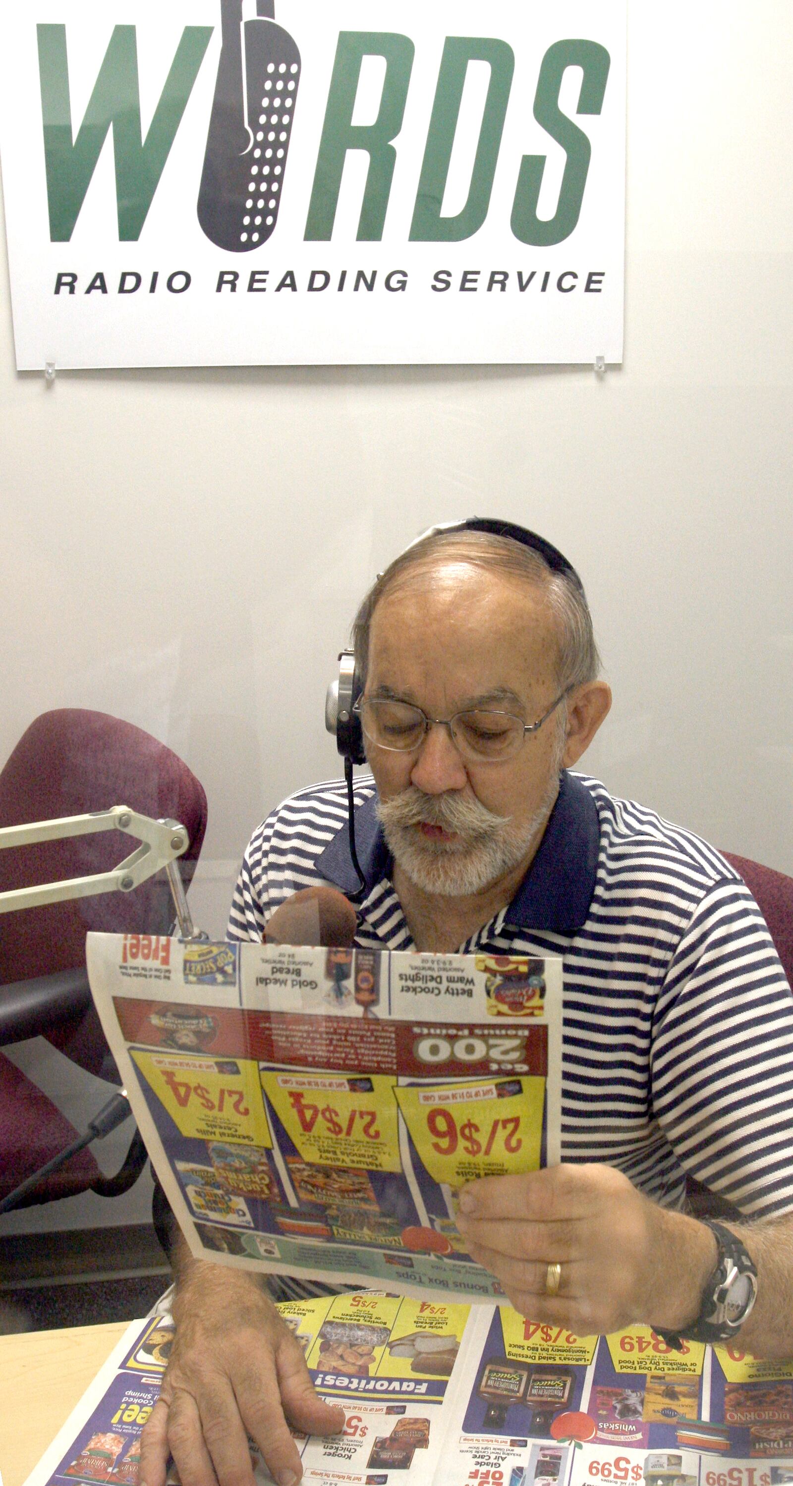 A volunteer reads the newspaper ads for the WORDS Radio Reading Service, which is sponsored by Goodwill. The program serves Miami Valley residents with visual disabilities. STAFF FILE PHOTO
